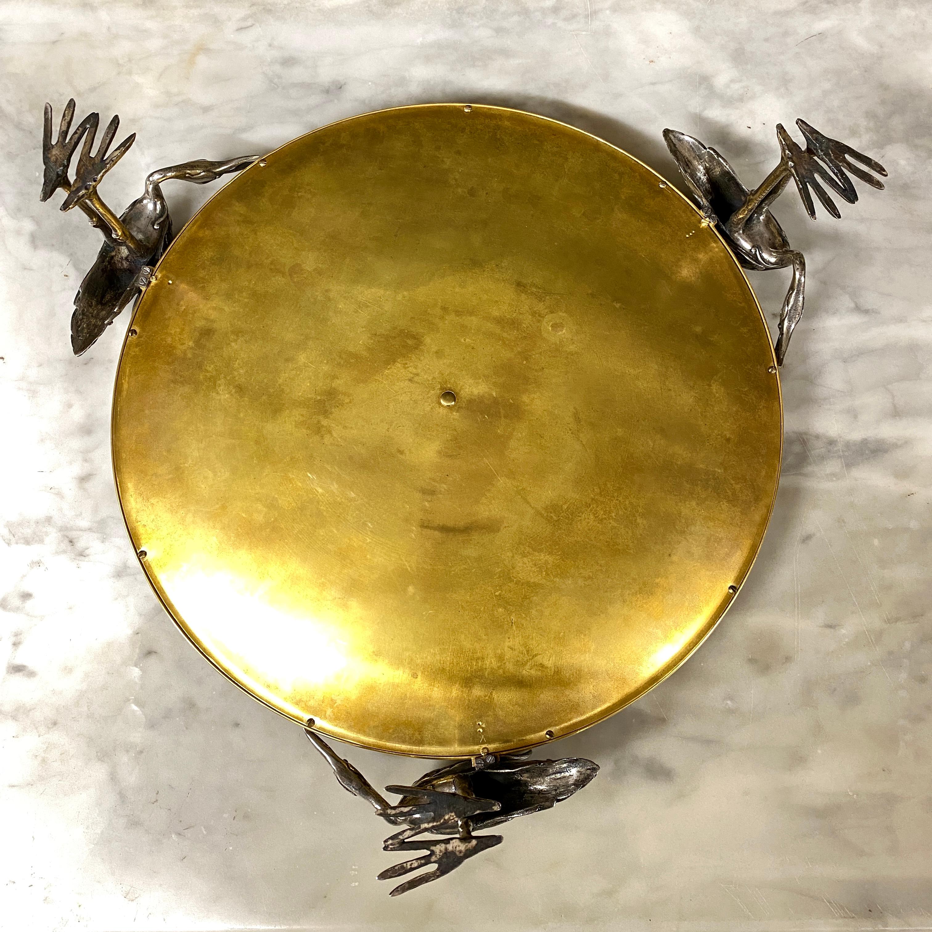 Grande coupe en bronze doré et bronze argenté tenue par trois cigognes formant la base. Il est décoré d'une marqueterie centrale en ivoire et en bois précieux (palissandre, bois de rose) cloisonnée en laiton ciselé. Cette décoration représente un
