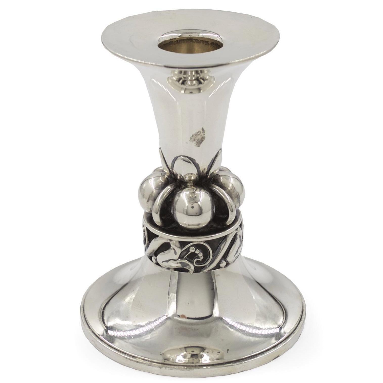 This fine sterling silver candlestick designed by Alphonse La Paglia for Georg Jensen from the middle of the 20th century is his distinctive no. 118 form. A complex design, it features a flared sconce with a tapered baluster surrounded by spheres