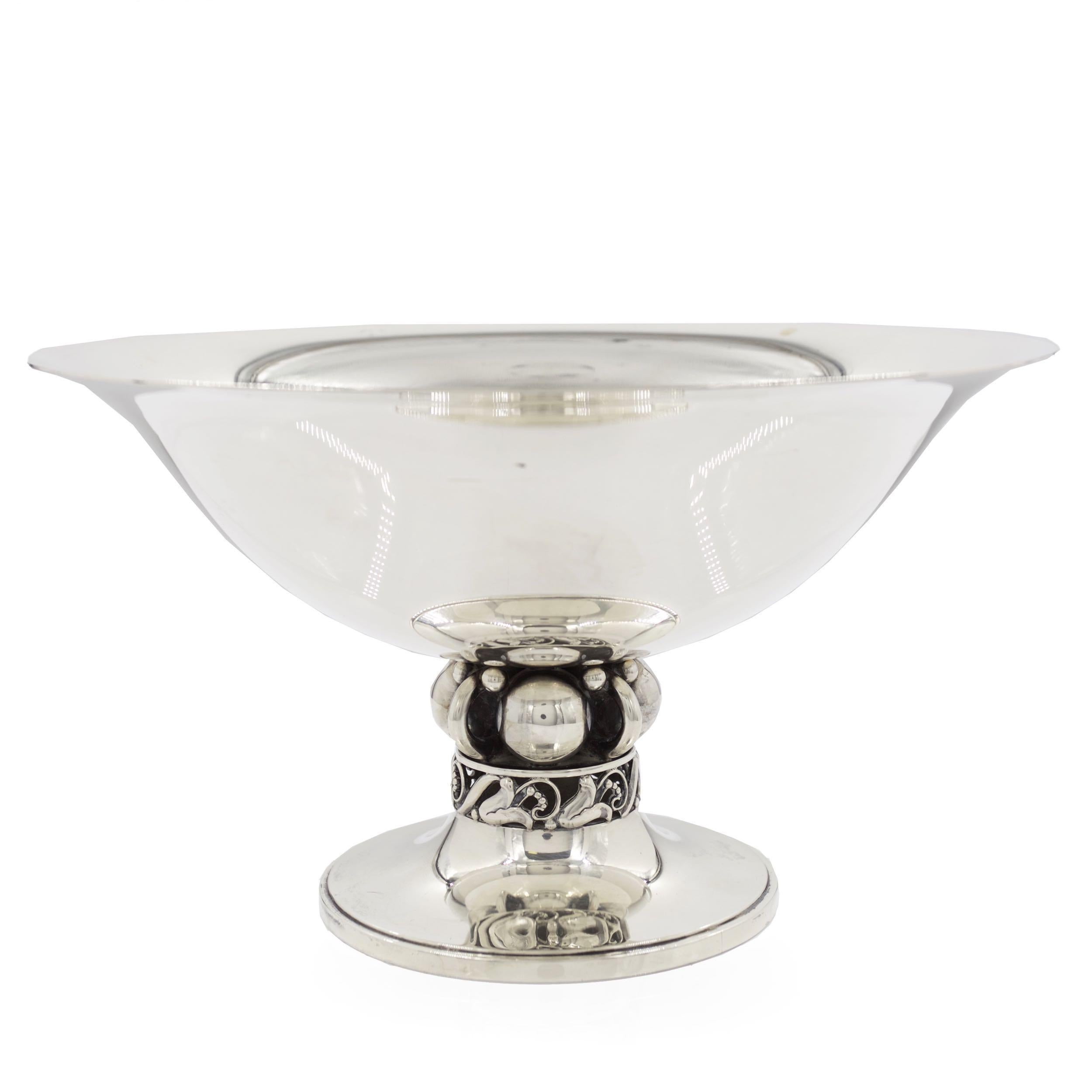 This fine sterling silver centerpiece bowl was designed by Alphonse La Paglia for Georg Jensen circa mid-20th century in his distinctive no. 118 form. It features a broad bowl with flared rim raised over a complex baluster of four spheres and wire