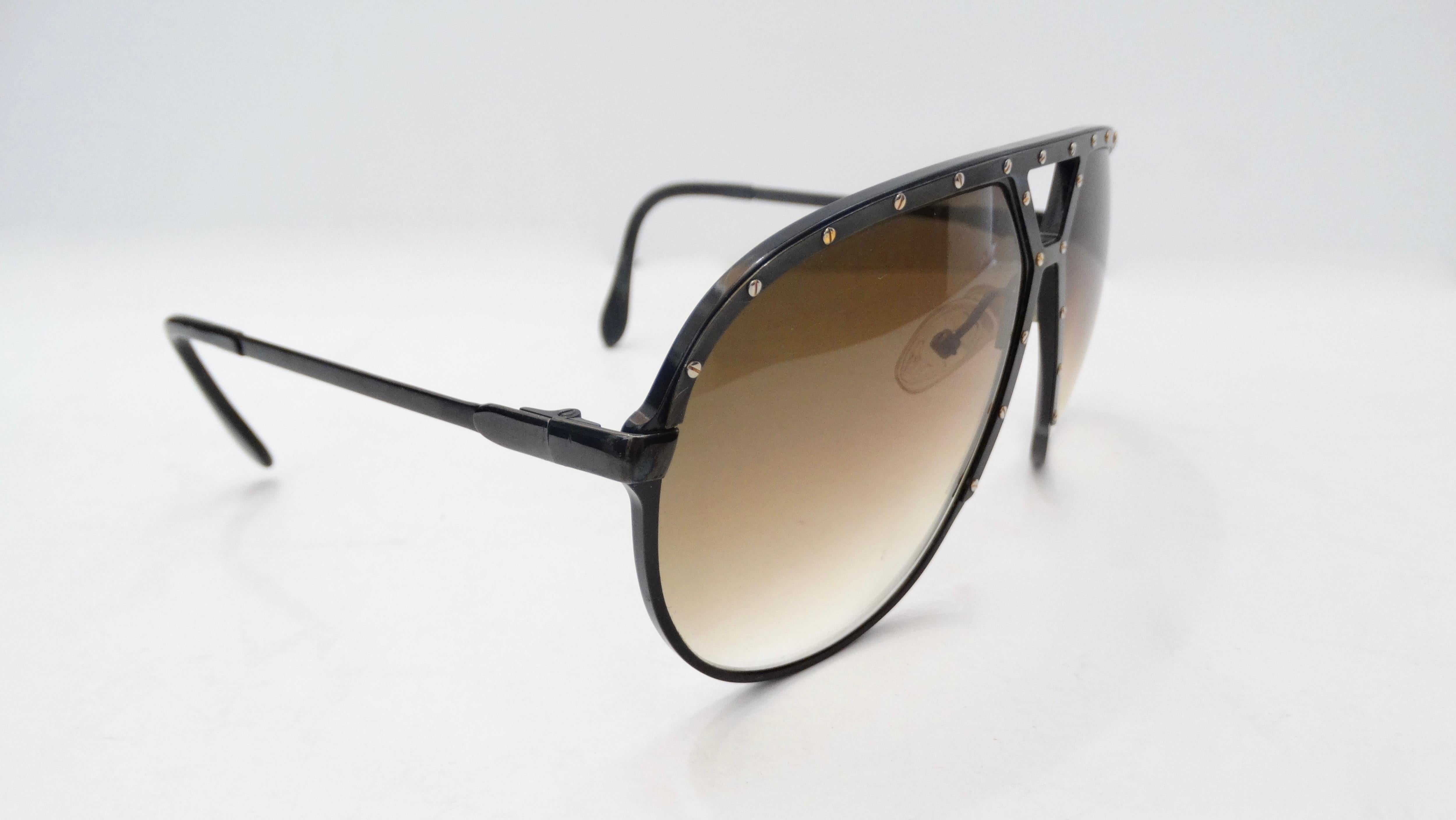 The Most Amazing Sunglasses! Circa late 1980s, these Alpina M1 sunglasses are an aviator style and feature a black metal frame with silver plated flat head screws on the top bar and down the bridge. Dark brown gradient lenses. The most killer