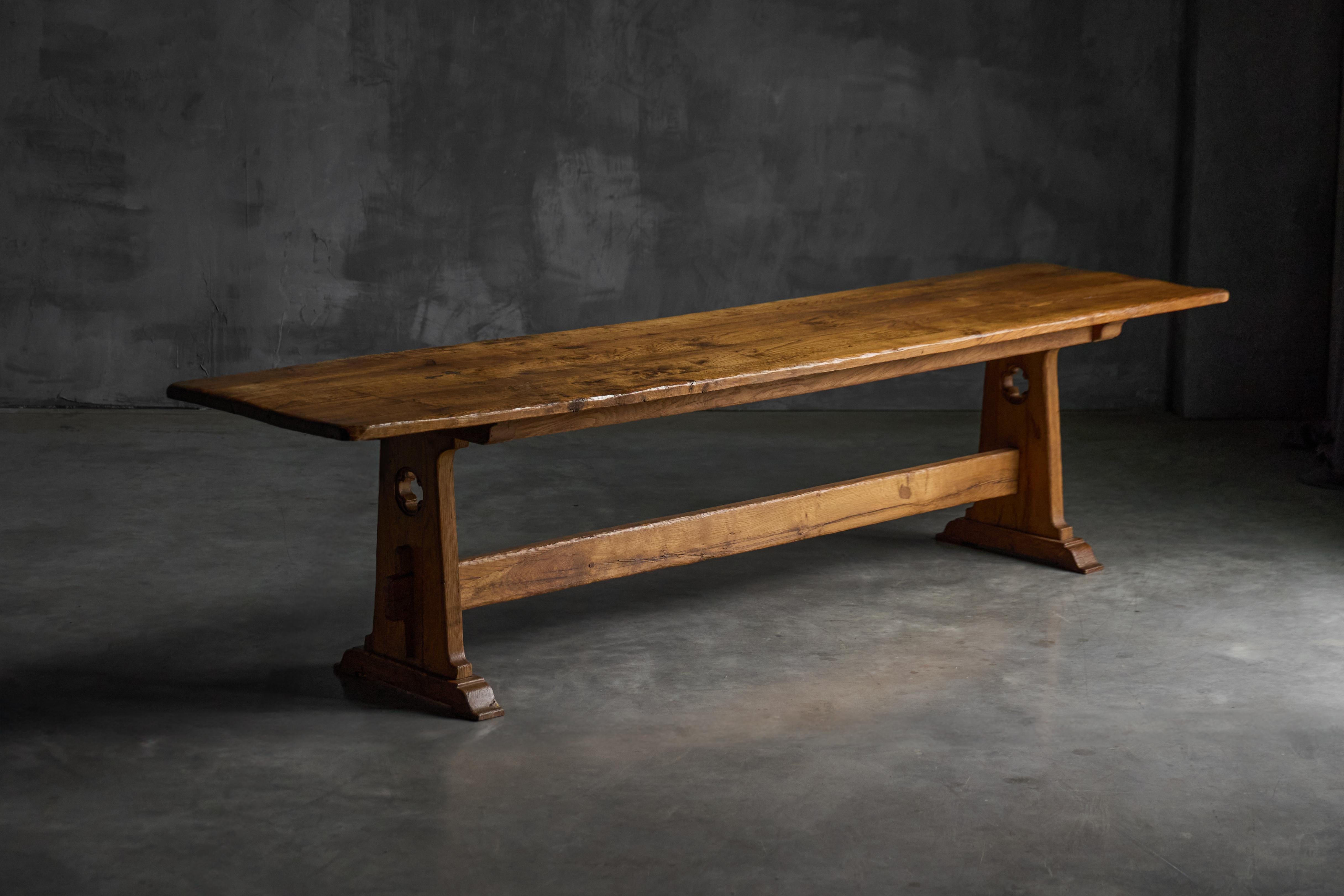 Esta mesa caballete alpina de mediados del siglo XX está fabricada en madera maciza con una superficie de textura profunda y veteado natural. El amplio tablero muestra una artesanía milenaria con bordes suavemente biselados y una rica variación