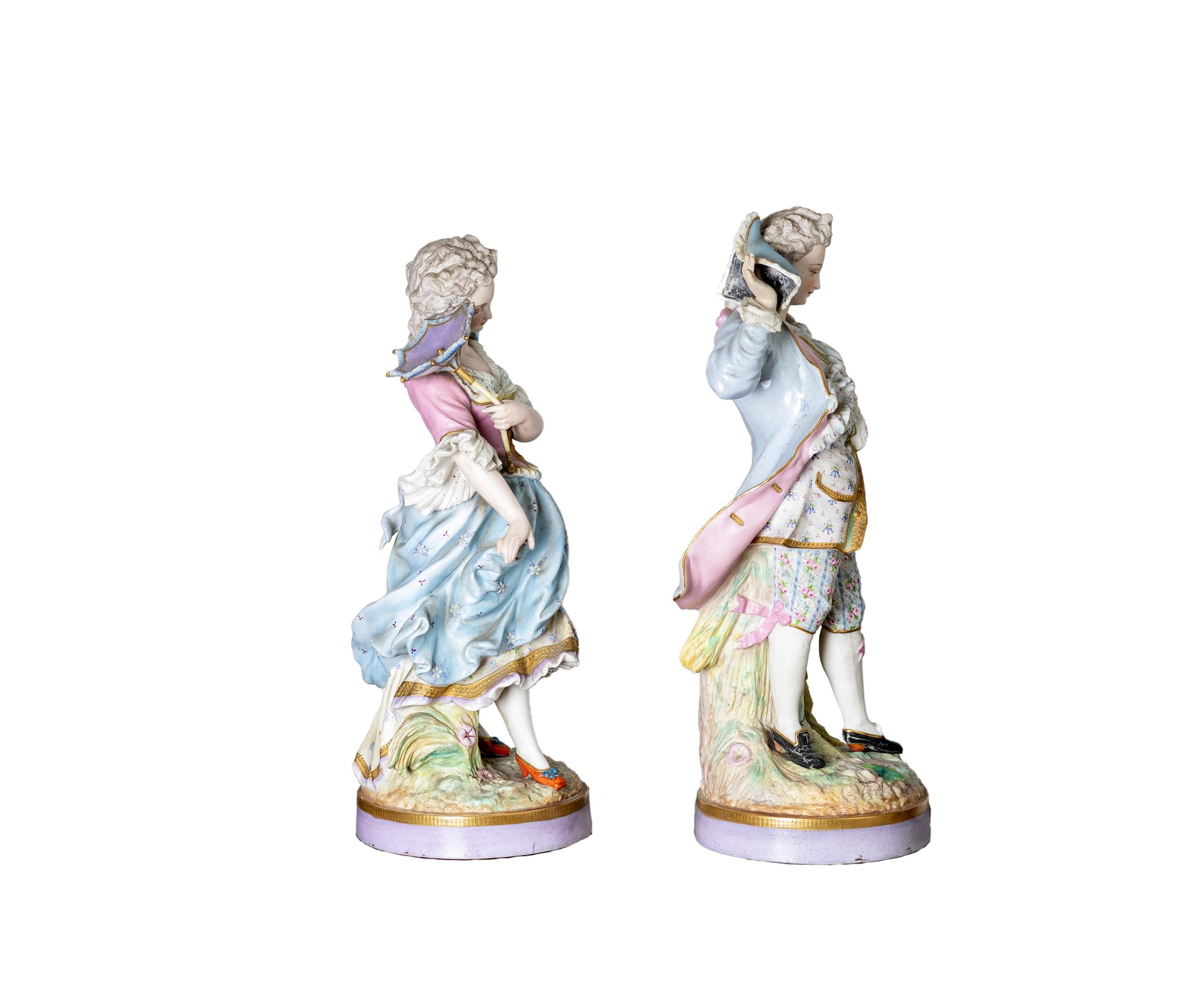 This pair of Baroque-style Limoges porcelain figurines was designed by Alpinien Margaine (French, active after 1854) and produced by the renowned Gibus et Cie foundry (1853–1972). 
Crafted in delicate baby blue, pink and gold tones, the pieces exude