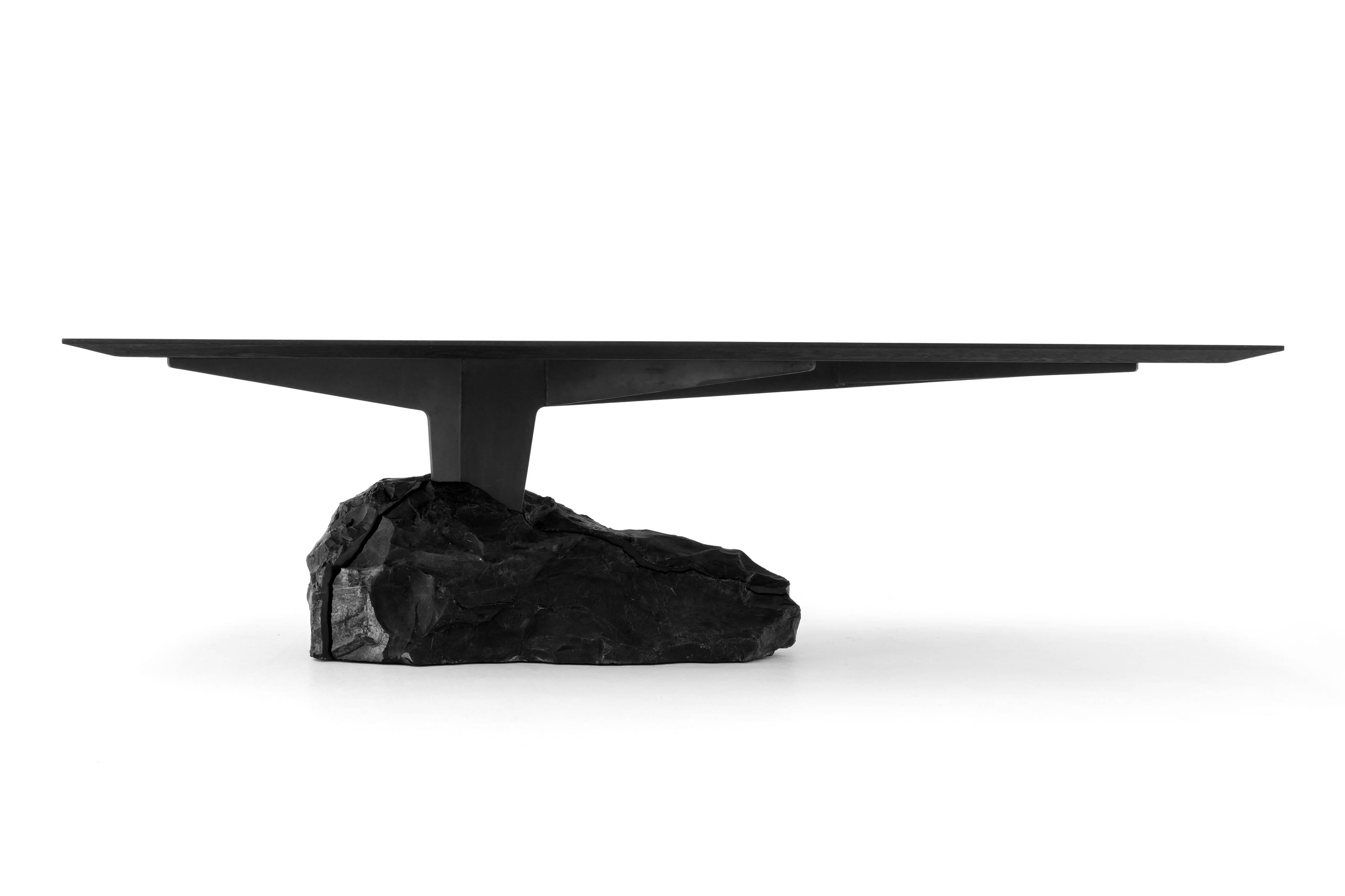 The dining table is characterized by visual balance. The 2.6-meter long dining table achieves its shape from the counterweight formed of a large piece of black Orizaba marble stone. The marble creates the necessary weight to support the steel