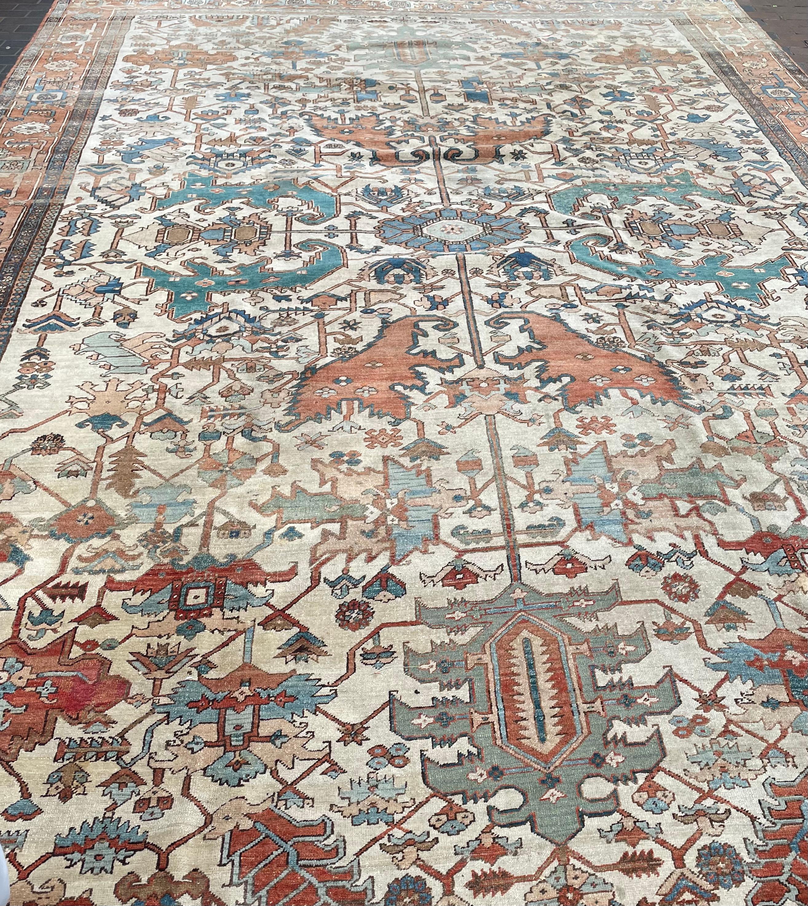 Tapis Heriz
Nord-ouest de la Perse, vers 1890

Superbe design tribal avec médaillon central sophistiqué
Le champ ivoire avec une rosette centrale flanquée d'une vinerie florale stylisée à grande échelle est entouré d'une bordure de palmettes et de