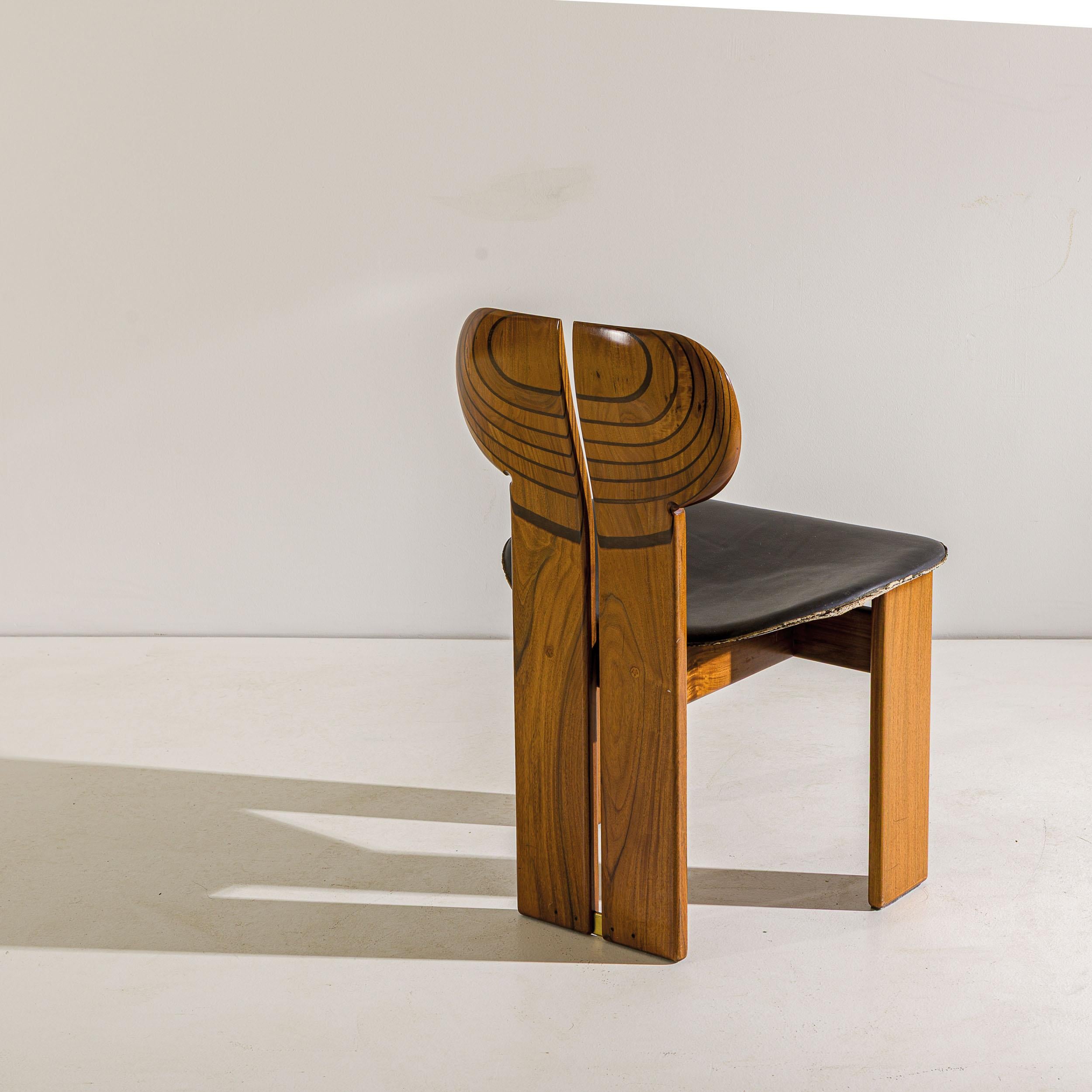 Raro e classico set di sei sedie modello Africa della serie Artona. 
Noce massiccio, intarsi in legno ebanizzato, pelle padellata.
 Produzione Maxalto, 1975 circa.
 Marchio impressionato. logo