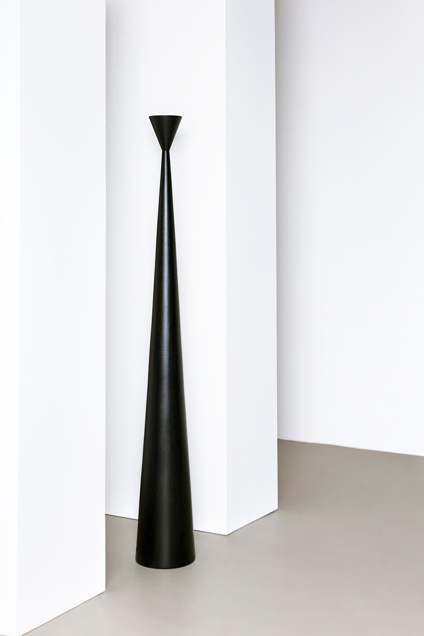 Alta is a floor lamp whose upward light creates a diffused illumination that hangs over the piece. The design seeks inspiration in the characteristic monumentality of the Brazilian Modernist period.
Its shape is composed by 2 conical blocks of solid