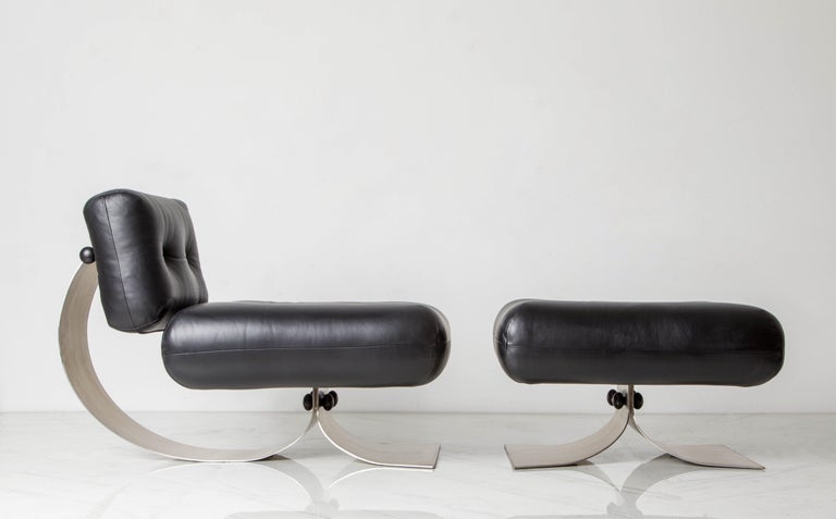 This beautiful 'Alta' fireside lounge chair and ottoman by Oscar Niemeyer for Mobilier International (France) features thick curved steel frames with tufted black leather cushions. The head rest is adjustable as can be seen in photos, and both