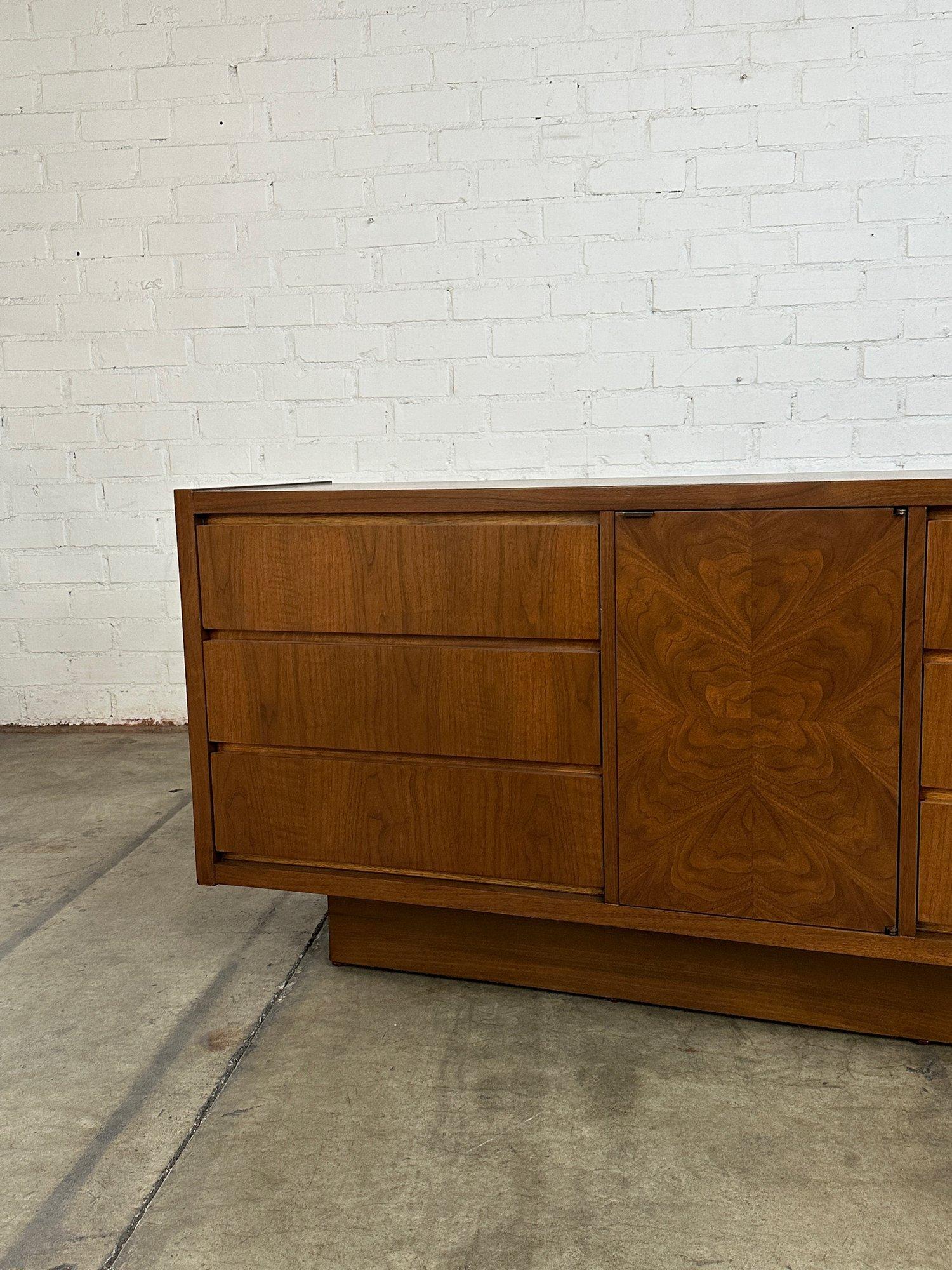 W66 D18 H29

Fully restored credenza with six smooth sliding drawers with under drawer pulls and open storage behind the starburst door panel. Shelf inside is stationary and can handle heavy weight. Item sits on a recessed walnut plinth base.