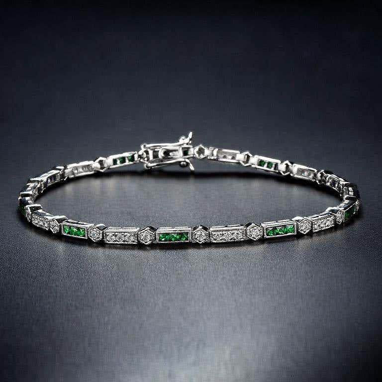 Luxuriant and colorful, this Aimée bracelet features alternating triple French cut emerald and round brilliant-cut diamonds. lends security to the classic Art-Deco style and a box clasp with hidden safety keeps this stunner secure. 14K White Gold.