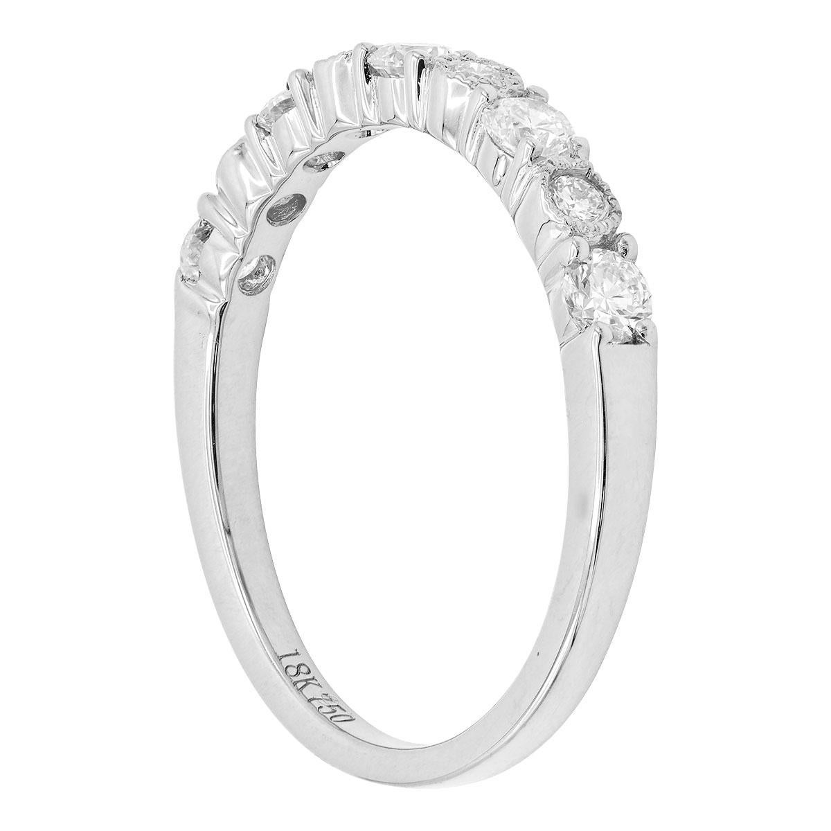 This beautiful 18 karat white gold ring is made from 2.4 grams of gold. Set in the gold are 9 total diamonds going halfway around the finger. There are 5 larger diamonds totaling 0.40 carats alternating with 4 smaller diamonds with a milgrain halo