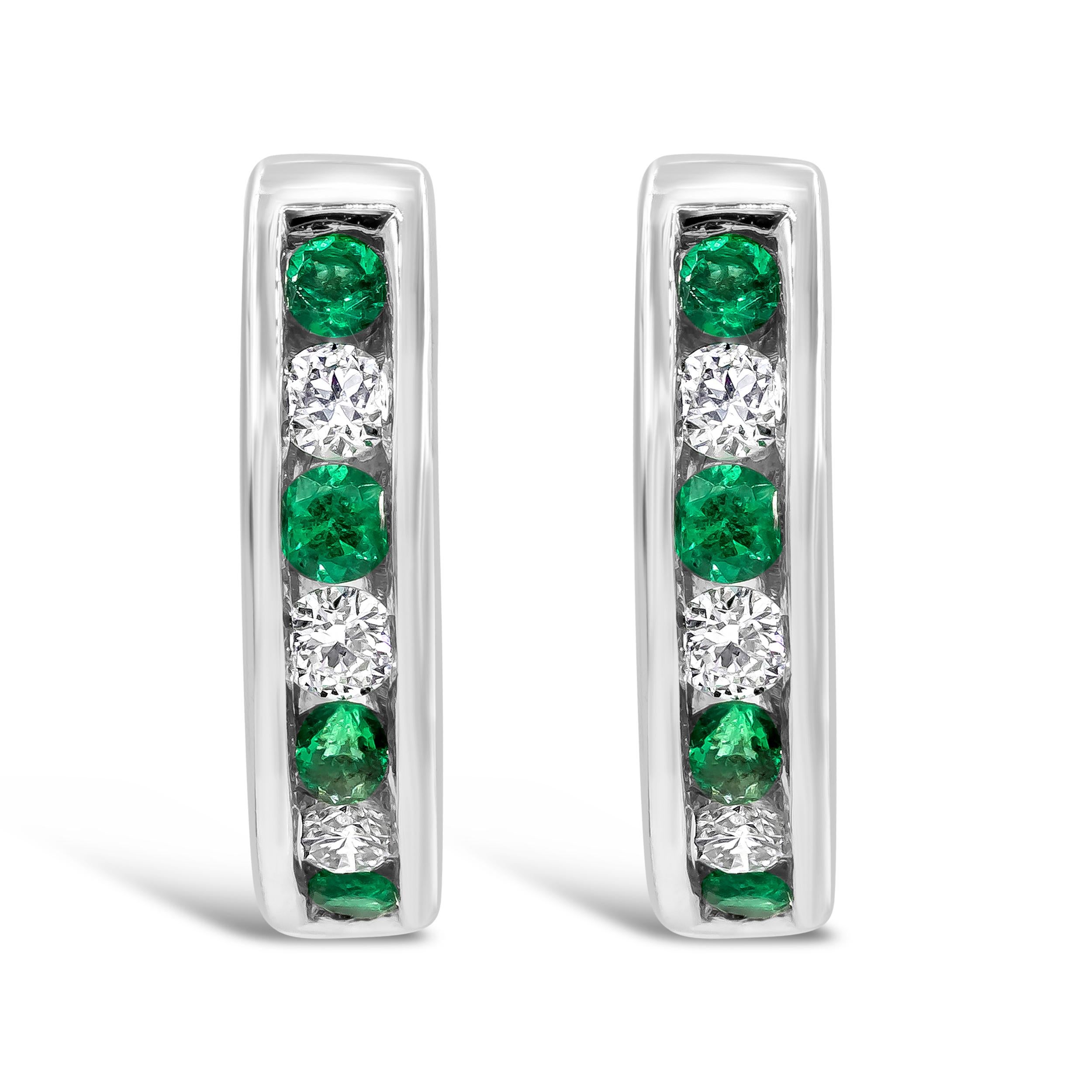 A simple pair of hoop earrings showcasing round green emeralds that elegantly alternate with round brilliant diamonds. Channel set in 18 karat white gold. Emeralds weigh 0.13 carats total; diamonds weigh 0.11 carats total.

