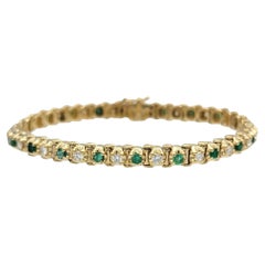 Pulsera con líneas alternas de esmeraldas y diamantes en oro amarillo de 14 quilates