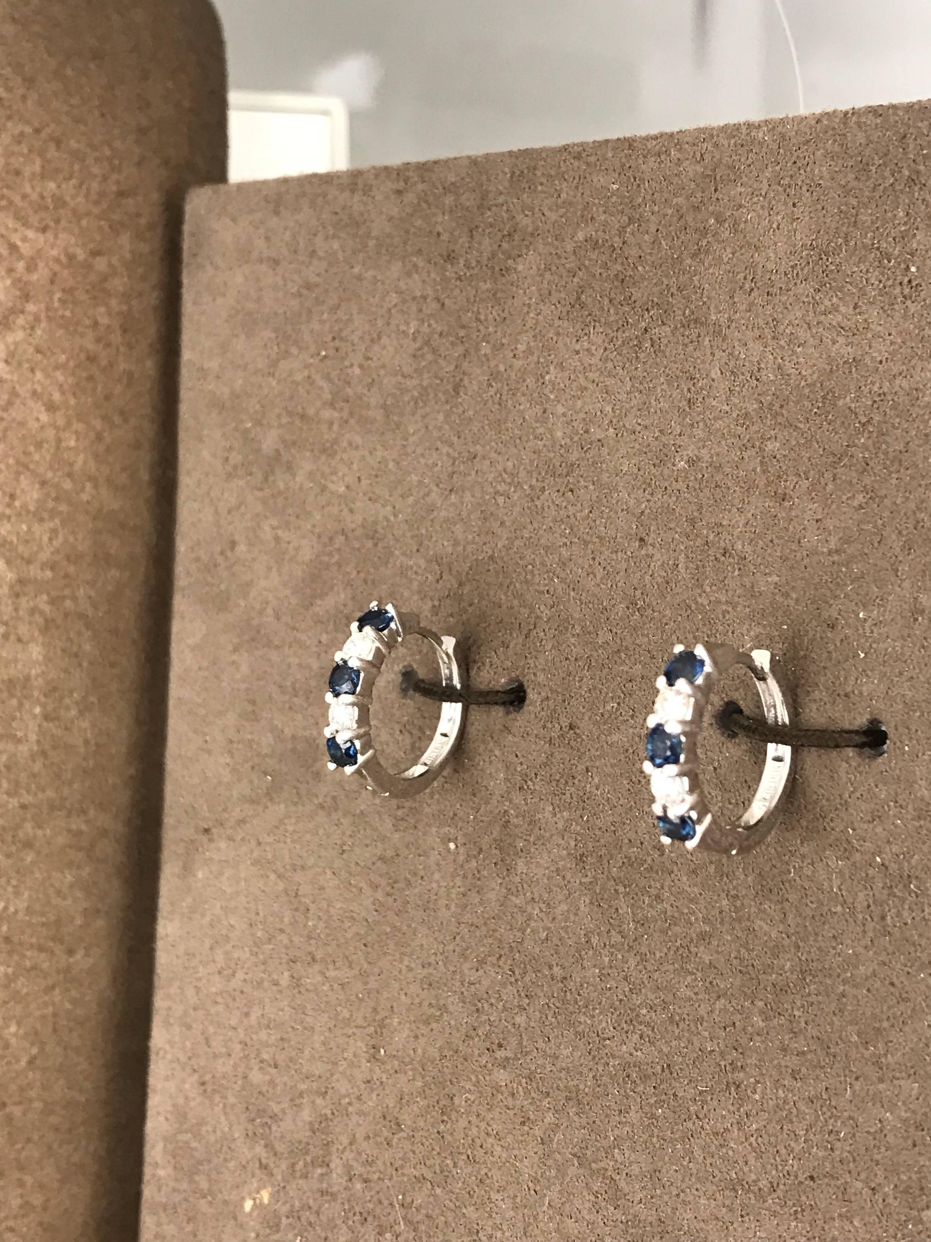 Contemporary, earrings with alternating Sapphires and Diamonds set in a huggie style setting. The metal is 18 karat white gold.
The (4) diamonds  measuring 2.7 millimeters have a total weight of approximately .28 carat. Quality of the diamonds are