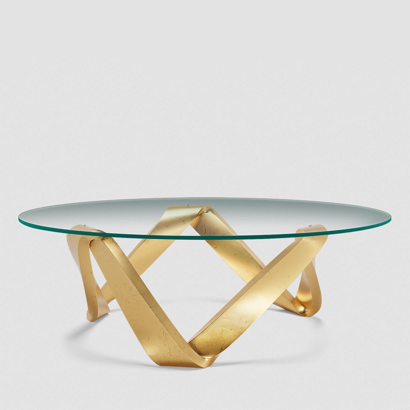Table basse Altus avec plateau en verre trempé transparent 
et avec base en bois massif de mahognay sculpté à la main. 
Peint à la main en finition or Nero.
Egalement disponible sur demande en bronzage ou tabac ou 
finition noir mat ou feuille