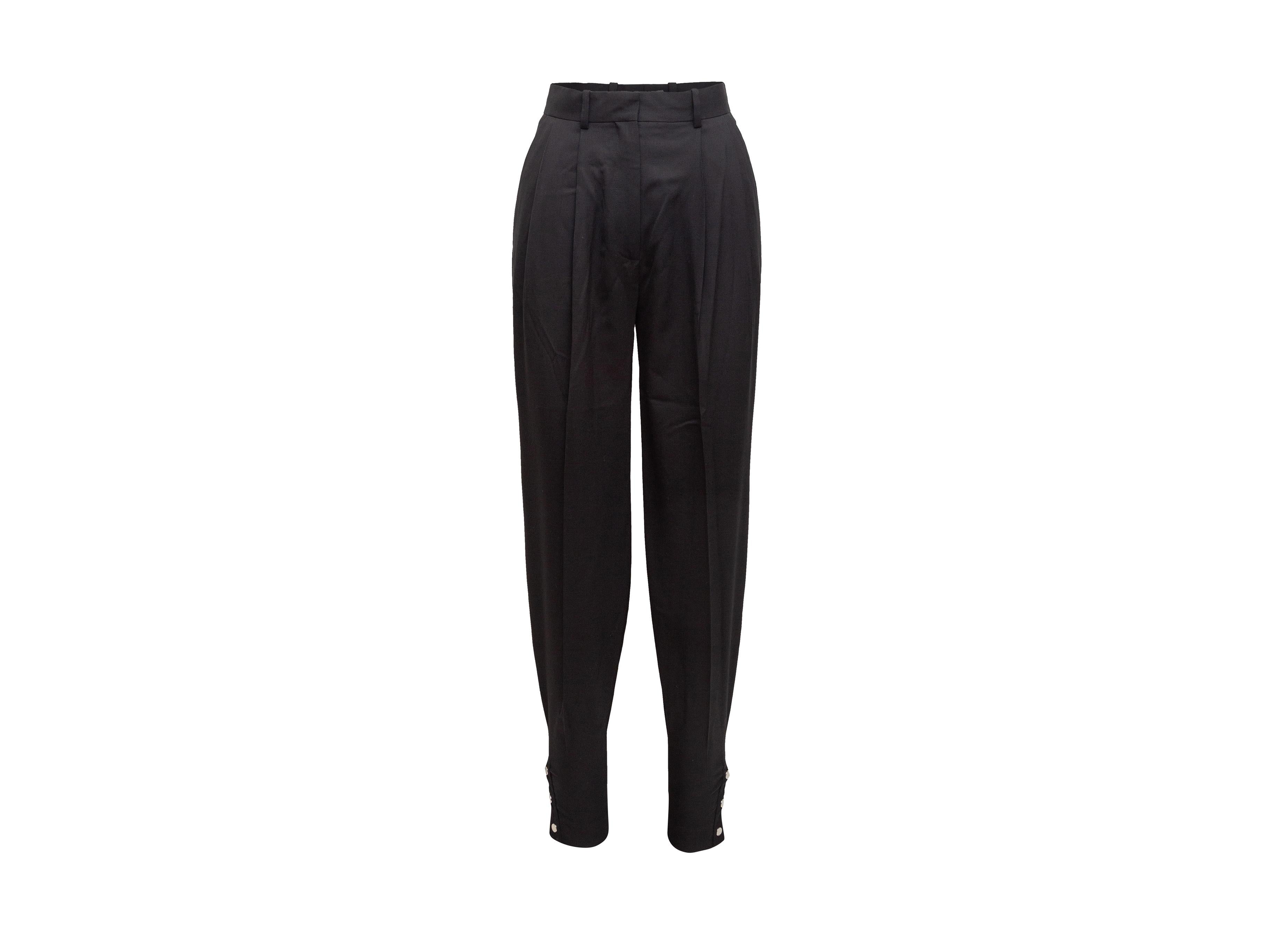 Product details: Black wool pleated tapered trousers by Altuzurra. Four pockets. Buttons at leg openings. Zip and hook-and-eye closures. Designer size 34. 26