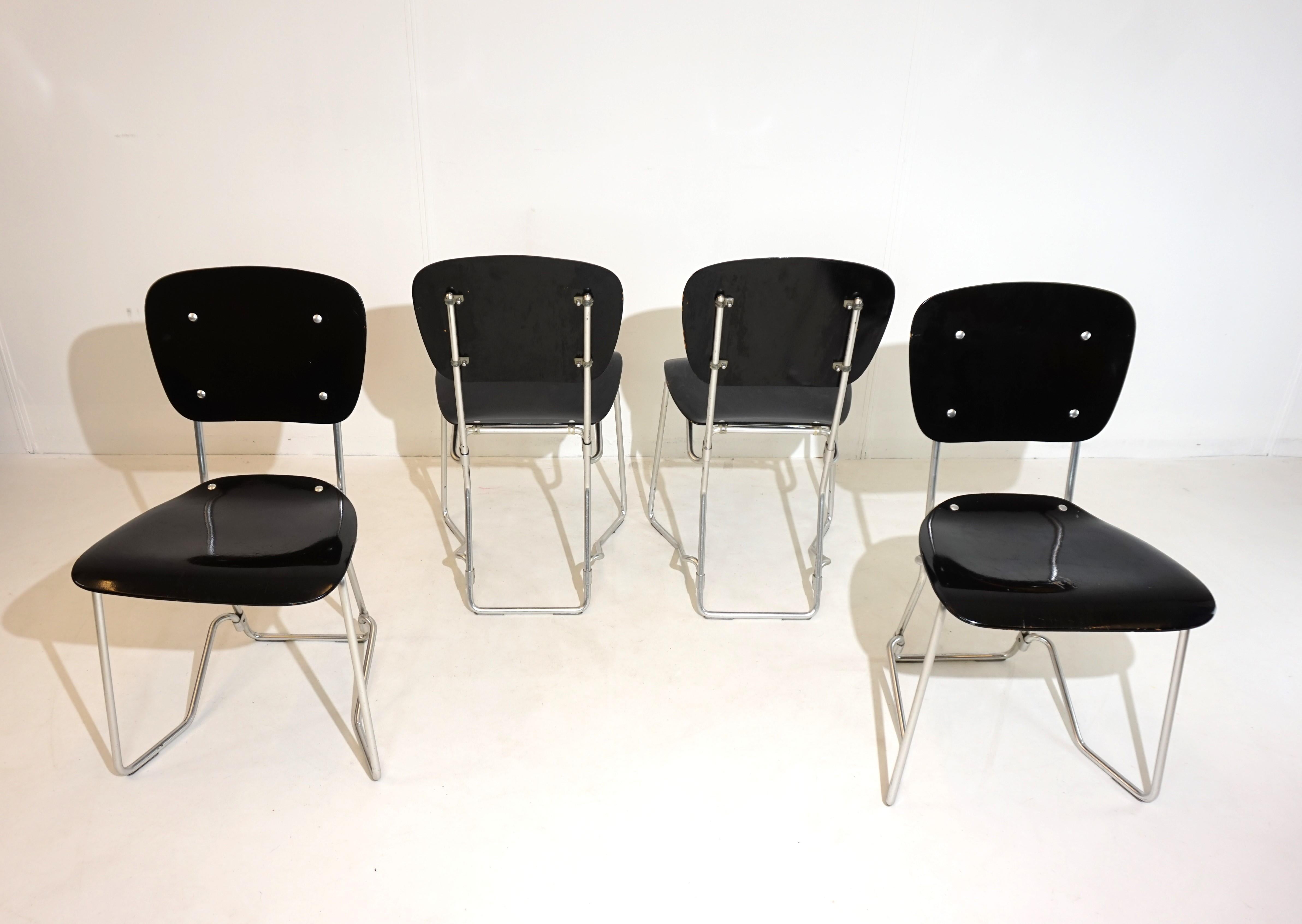 These design classics from the 50s, with the typical aluminum frame and black wood, are in good condition. The folding wooden seats and backrests have a beautiful appearance and show only minimal signs of wear.  One of the chairs has abrasion of the