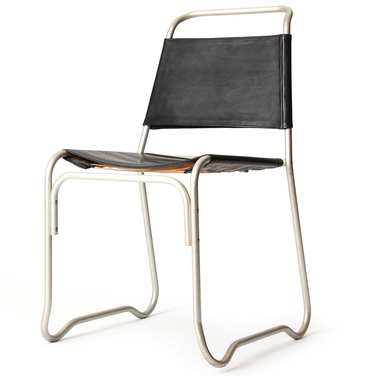 A stacking chair having sculptural frames of tubular aluminum with black leatherette sling seats and back rests. Part of the permanent design collection of MoMA.