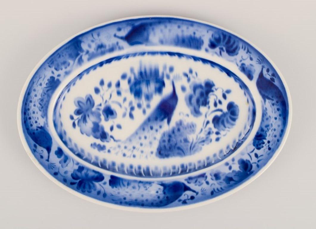 Aluminia, Denmark. Oval dish and two plates. Peacock pattern. Faience.
Approximately from the 1930s.
In good condition. One plate with significant wear. The other plate with natural cracks. The dish with a faded print motive.
Marked.
Plates: