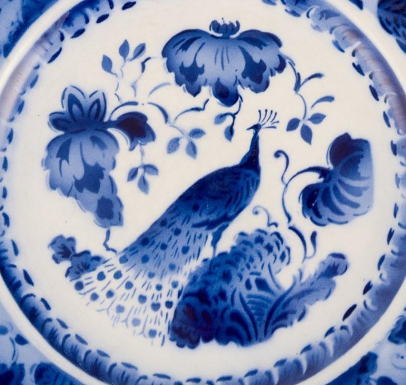 Milieu du XXe siècle Aluminia, Danemark. Plat ovale et deux assiettes en faïence. Motif paon. en vente