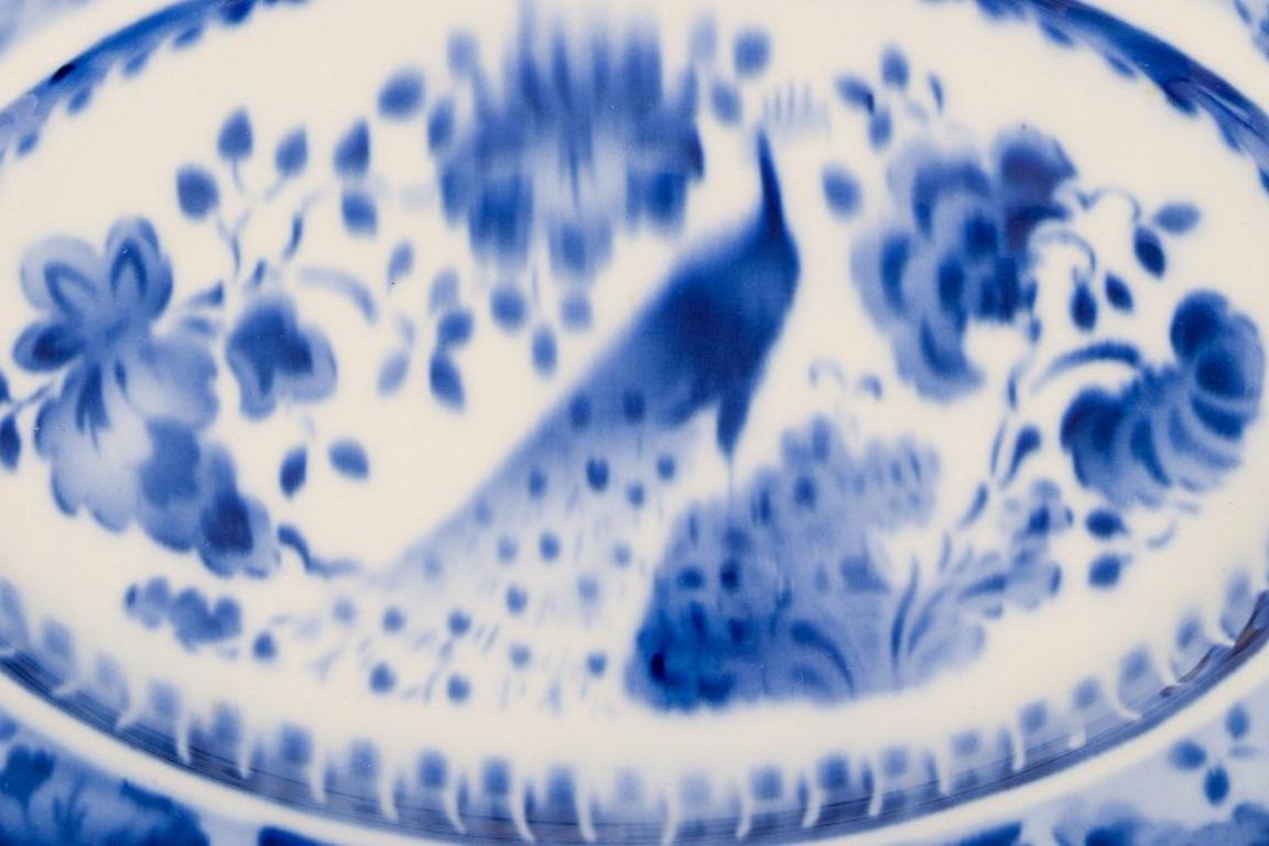 Faïence Aluminia, Danemark. Plat ovale et deux assiettes en faïence. Motif paon. en vente