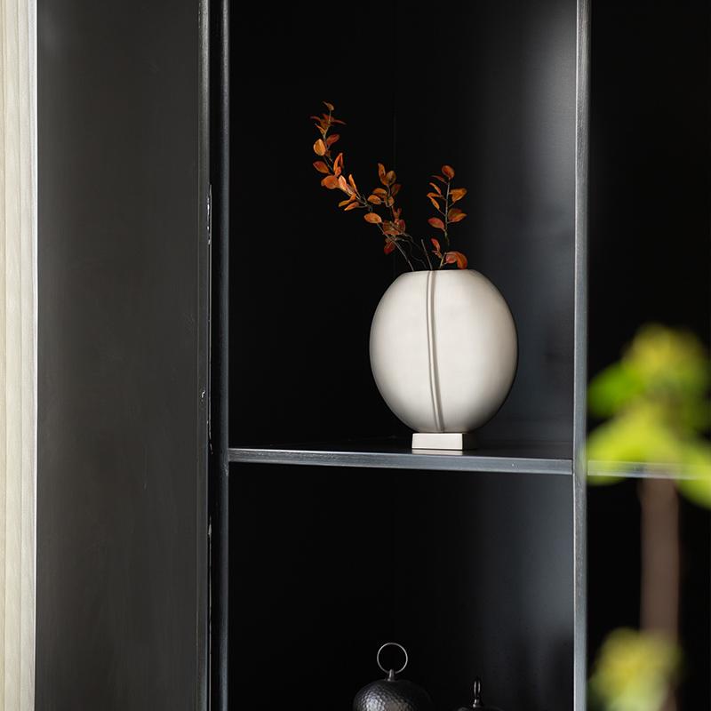 This flat round vase is a stunning and versatile decorative piece that is crafted from durable and long-lasting aluminium. The material not only provides a sturdy structure for the vase, but also has a natural shine that catches and reflects light
