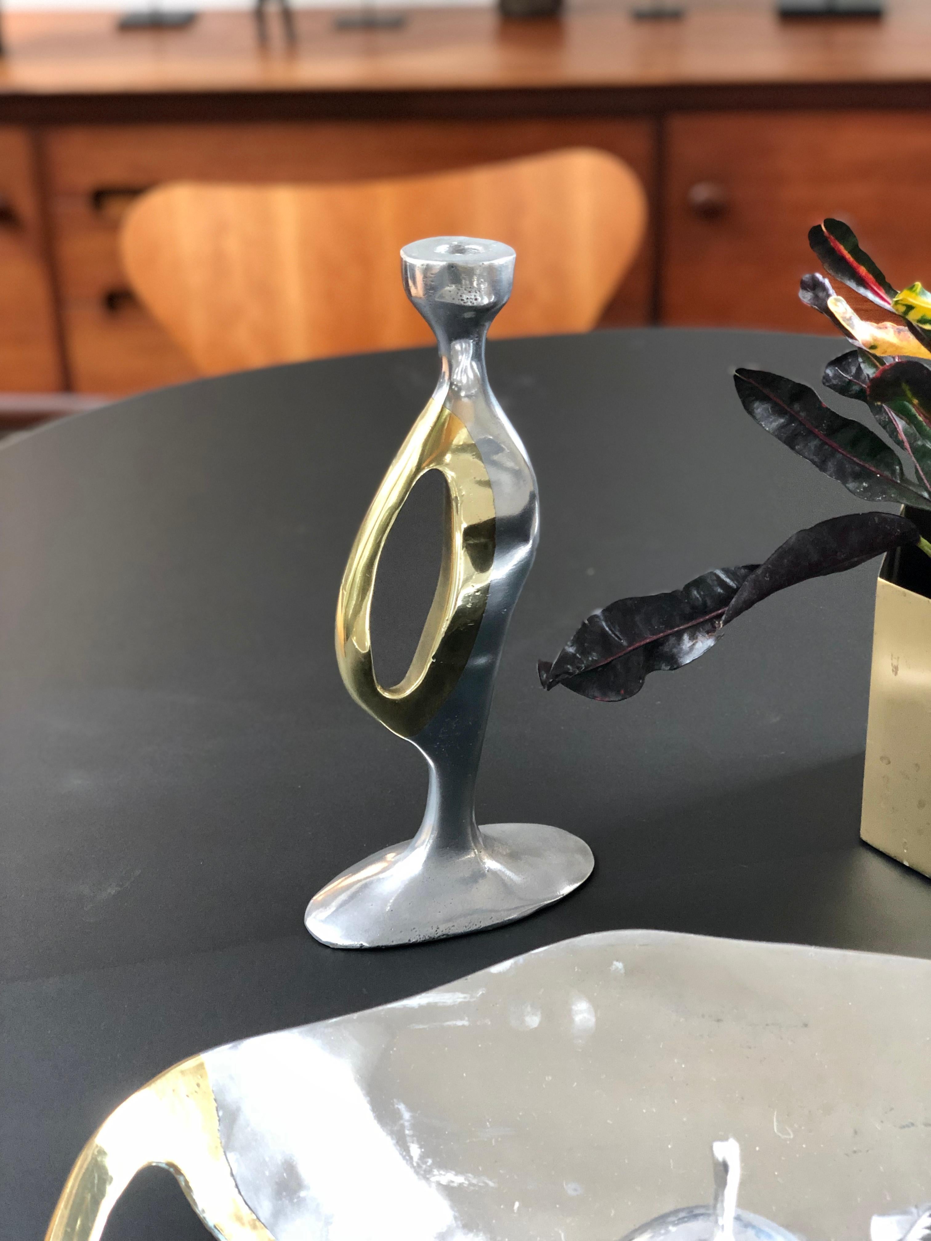 Aluminium and brass Brutalist style candleholder by Leopold, s.c., (circa 1970s). In the style of David Marshall, this candleholder stands on a solid aluminium base with a brass handle. The piece is curvy and irregular and therein lies its beauty.