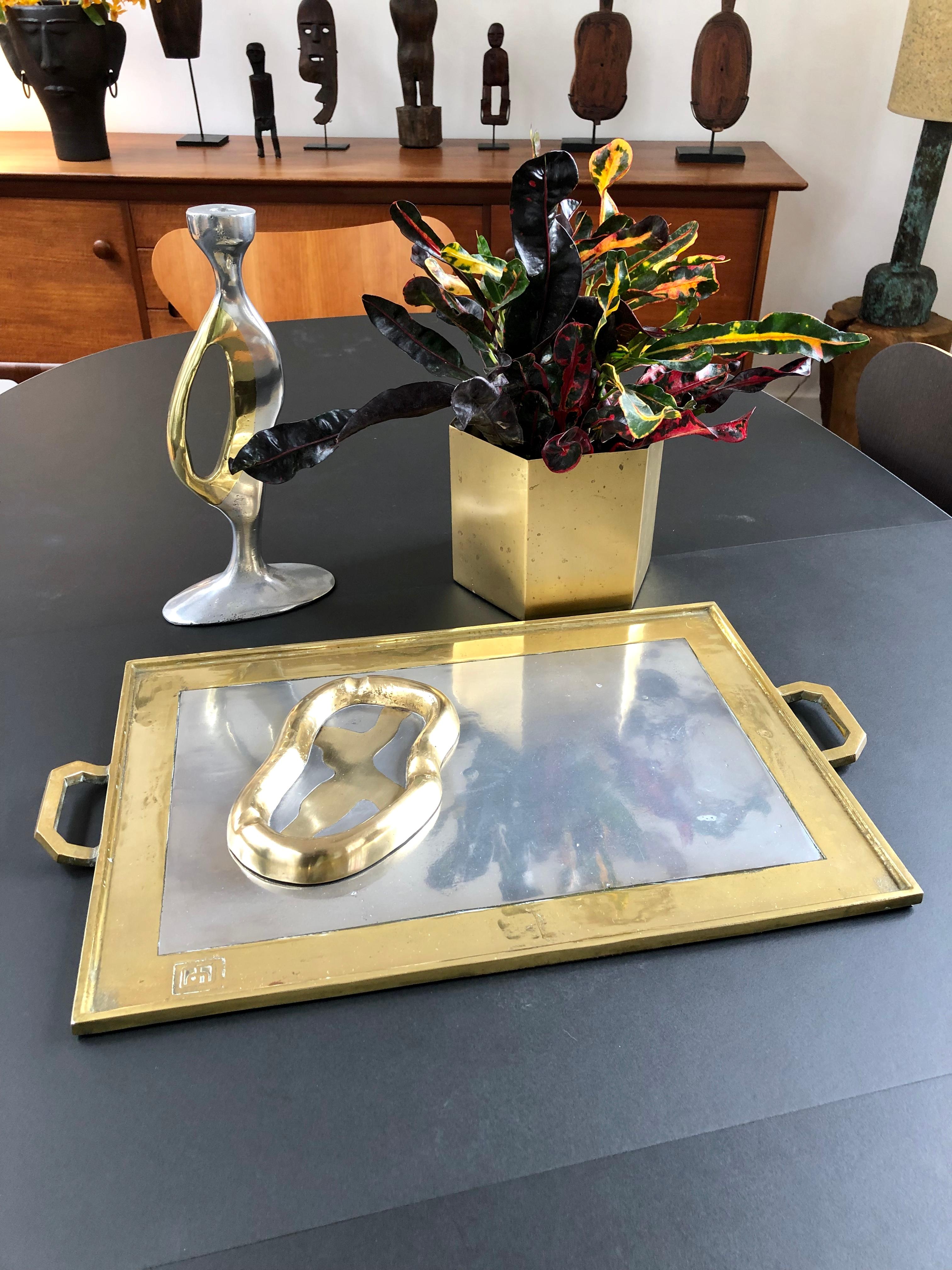 This aluminium and brass Brutalist style serving tray (circa 1970s) by David Marshall is weighty and wonderfully tactile with the maker's mark impressed on the brass surface. There are handles on the far ends of the brass which frames the shiny