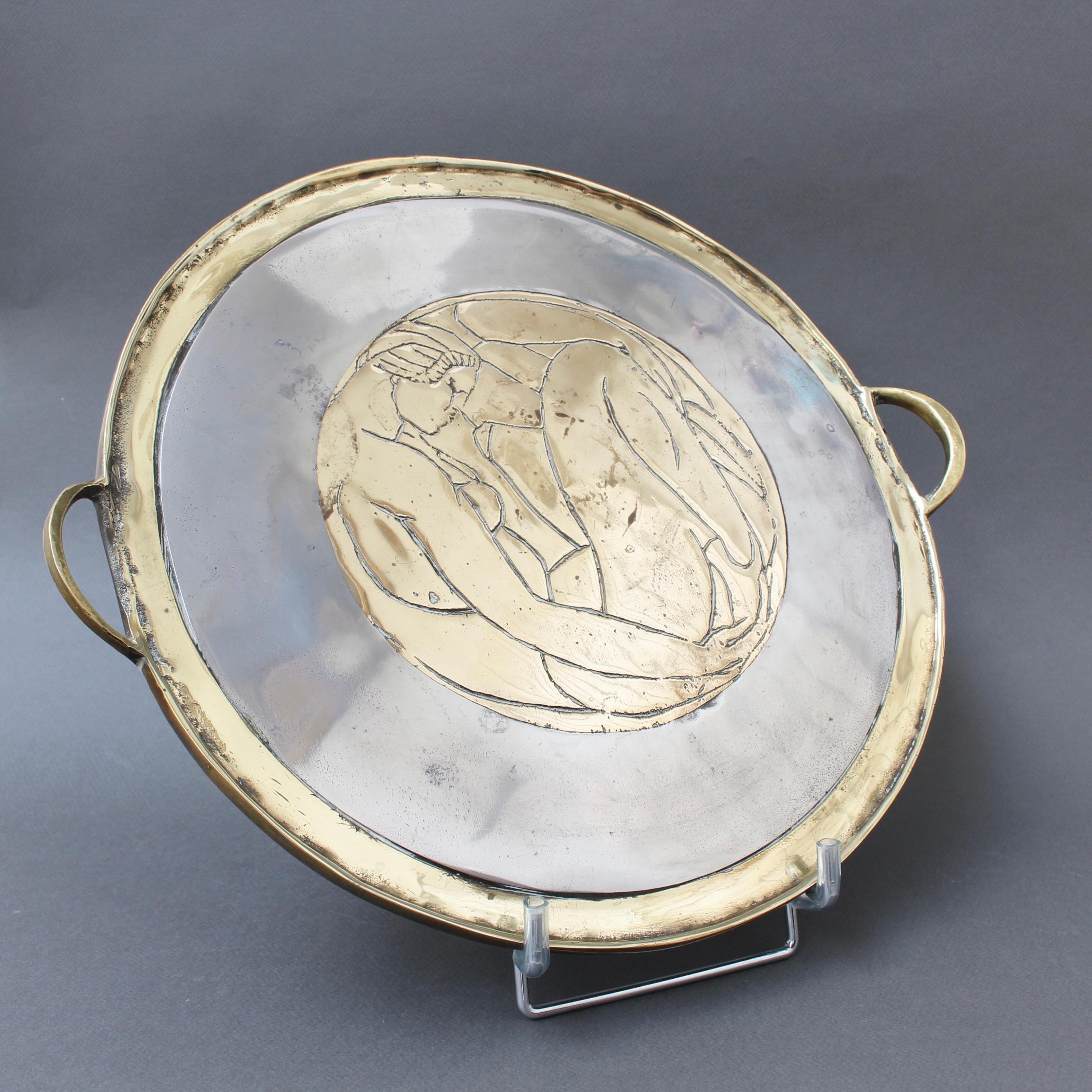 Aluminium and brass brutalist style serving tray by Leopold, s.c., (circa 1970s). In the style of David Marshall, this superb piece presents an art deco style image of a female nude incised in the centre brass circle. The tray is rugged, battered