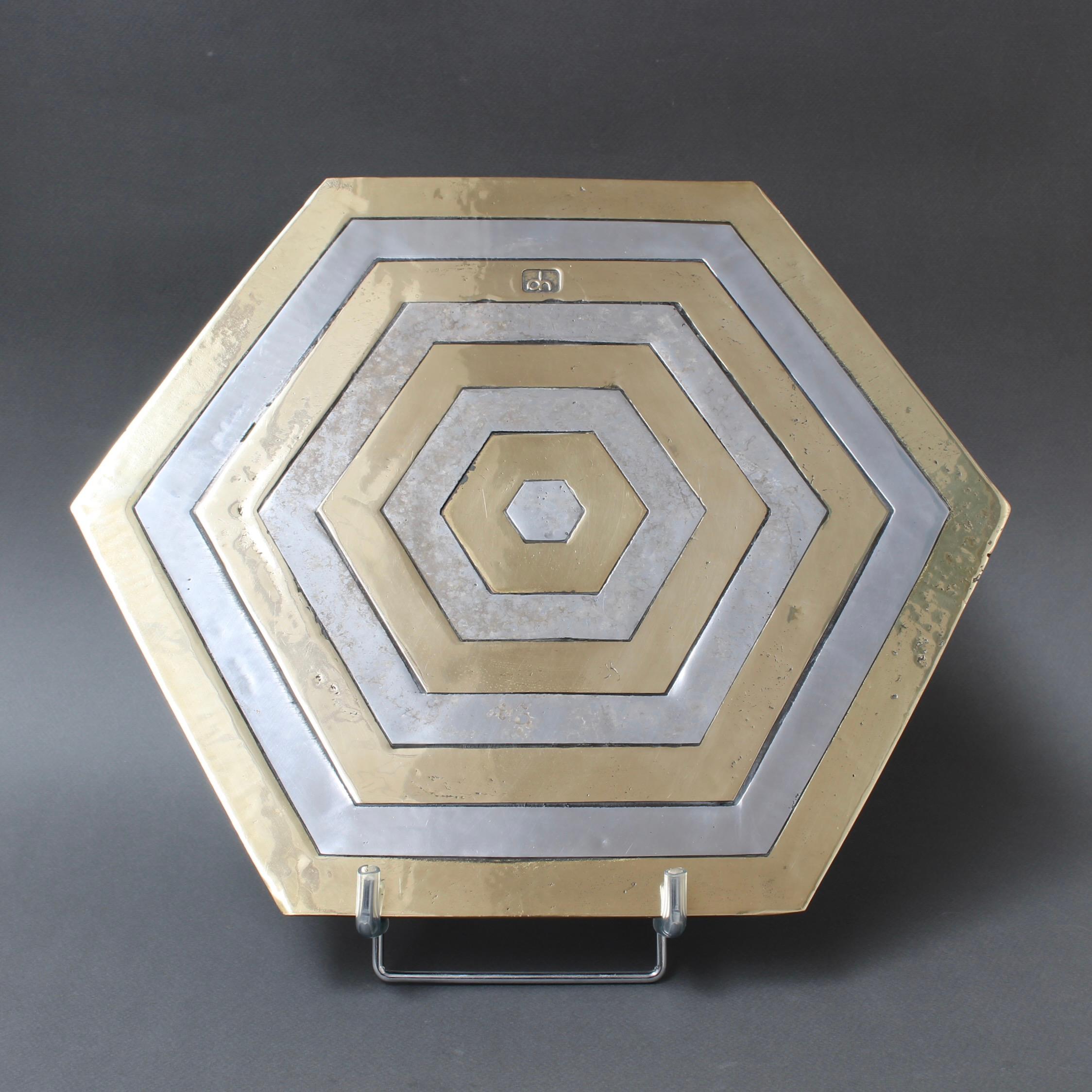 An aluminium and brass place setting / hexagonal salver by David Marshall (circa 1980s). This is rugged, weighty and wonderfully tactile with the maker's mark impressed on the brass surface. It would be completely suitable as a decorative piece on a