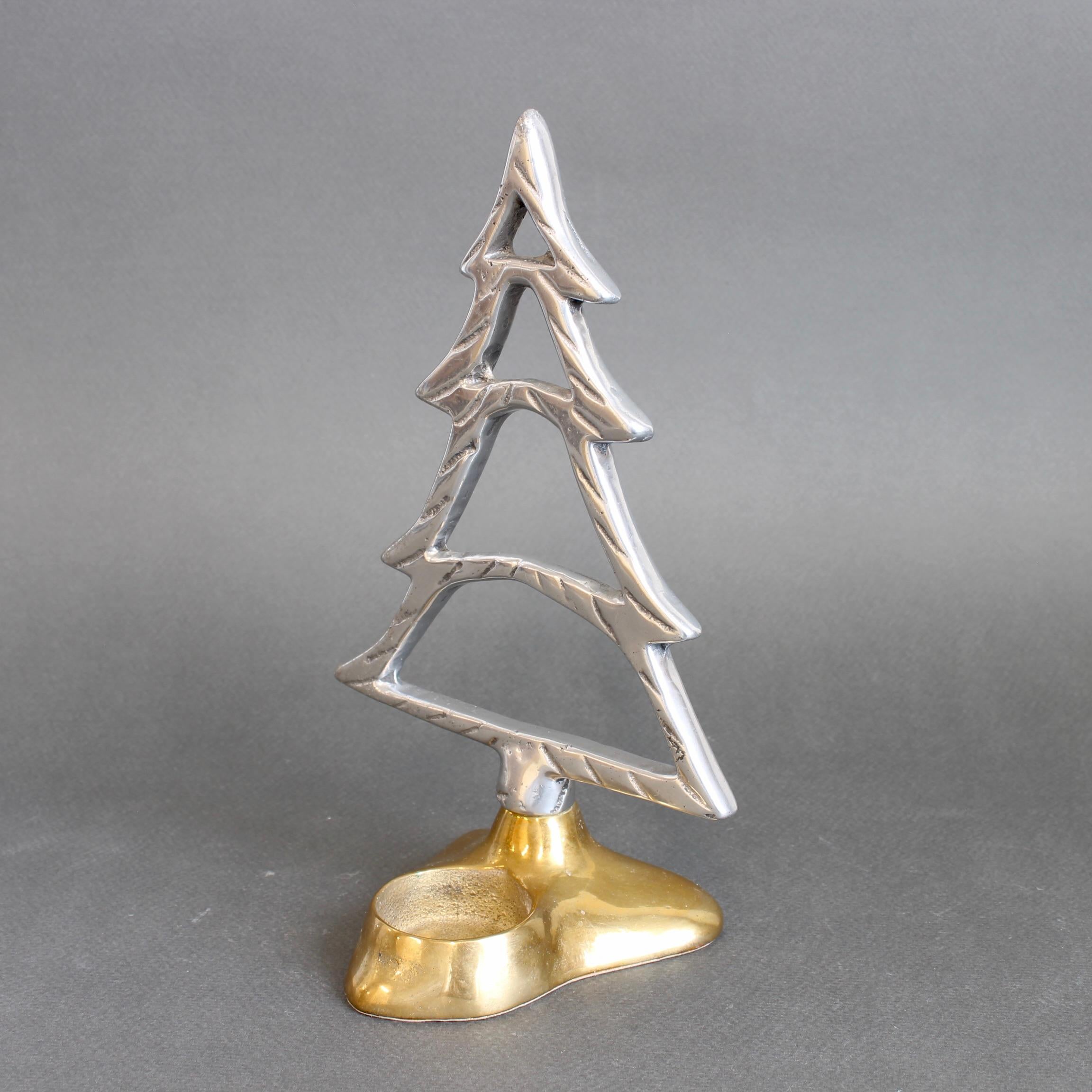 Table top Christmas decoration with tea light holder by David Marshall (circa 1980s). Cast in aluminium and anchored by a solid brass base, this sculptural piece features a recessed void designed to hold a single tea light—creating a subtle and