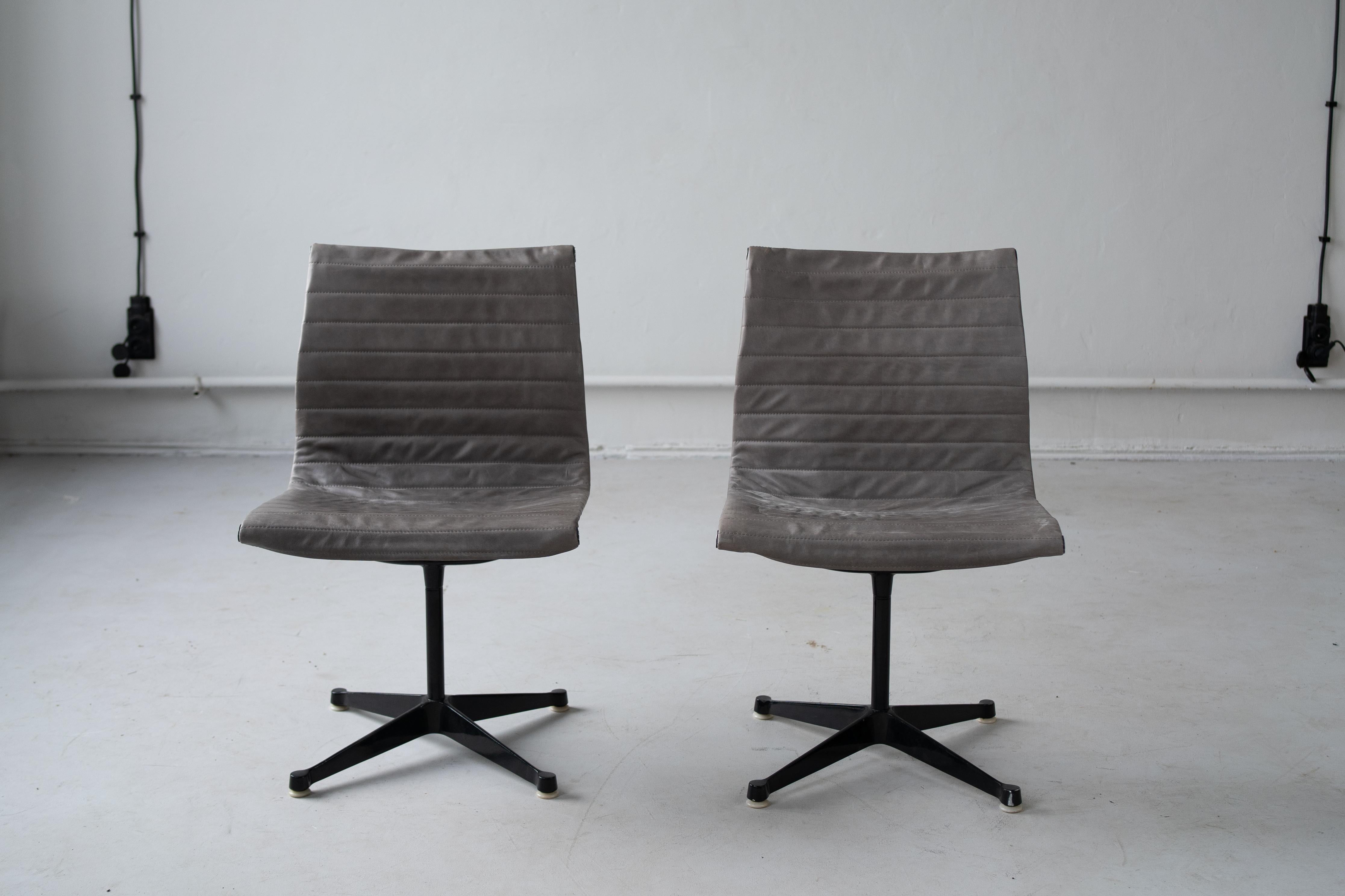 EA 116 chair designed by Charles and Ray Eames, in the late 50s.
Blach steel teggs and grey leather upholstery.
Functional , strong and elegant. 
A set of 2 chairs