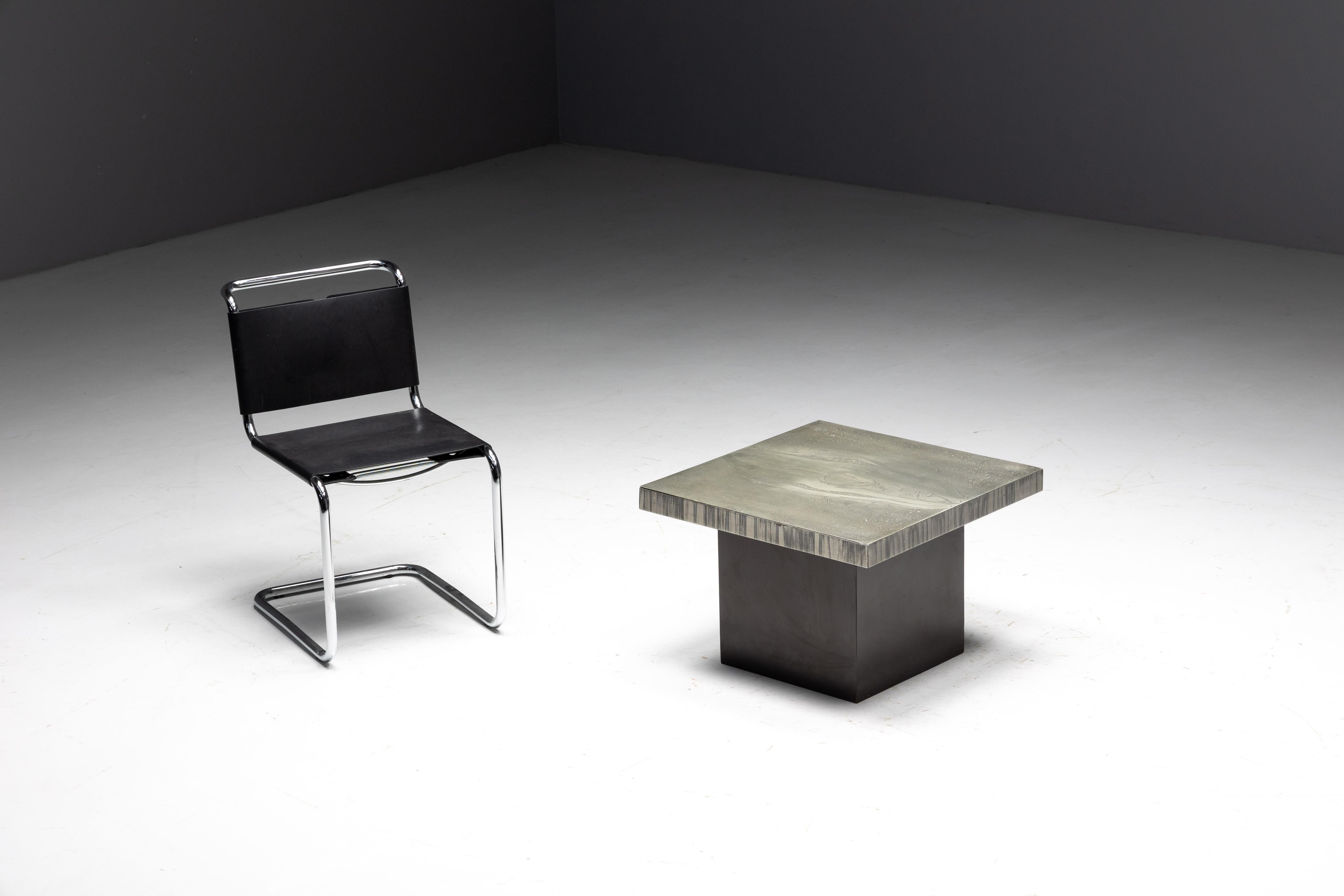Table basse carrée du designer belge Marc D'Haenens, la pièce maîtresse parfaite pour votre intérieur. Au cœur de cette table se trouve un plateau carré en aluminium, méticuleusement gravé à la perfection, mettant en valeur des motifs complexes.