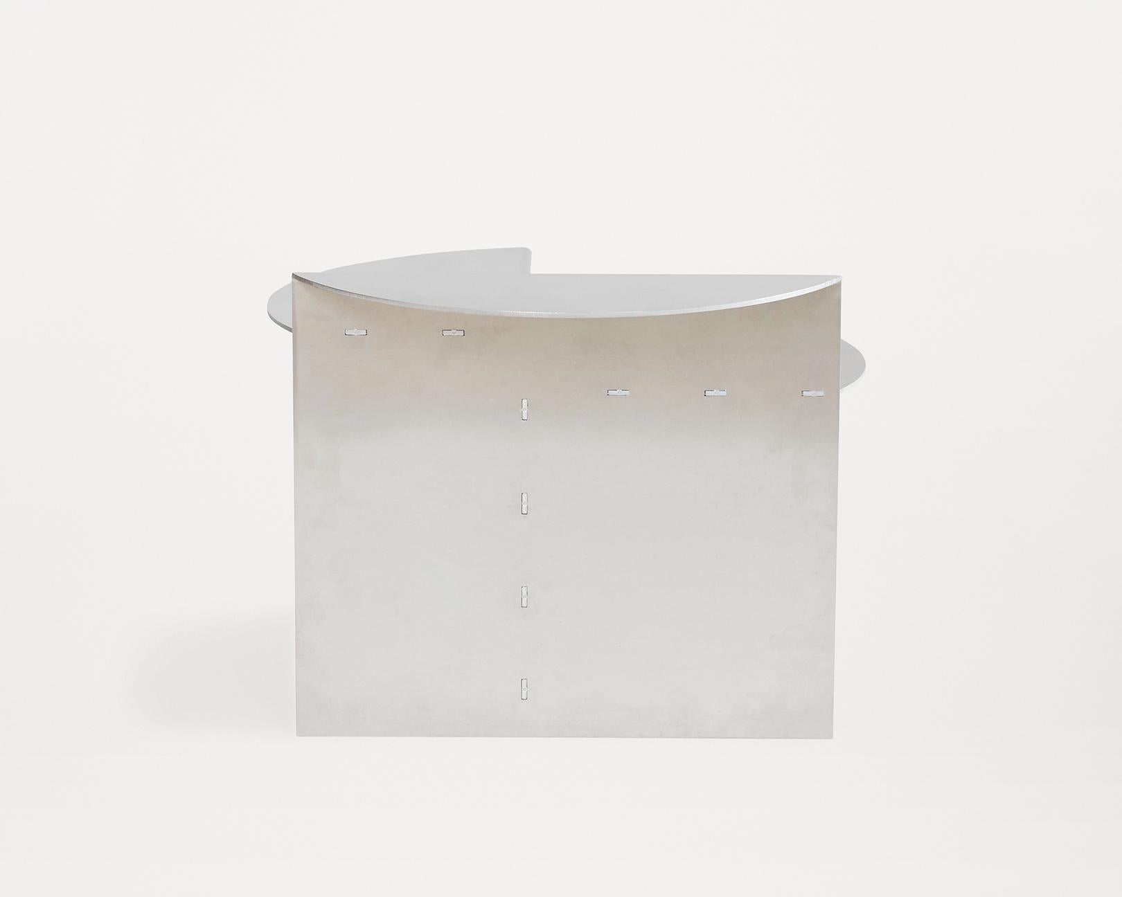 This beautifully crafted piece is made of untreated aluminium and is reminiscent of Donald Judd's design style. Due to the use of
untreated aluminium, patina and signs of wear will become soon noticeable in line with the designer’s intention to