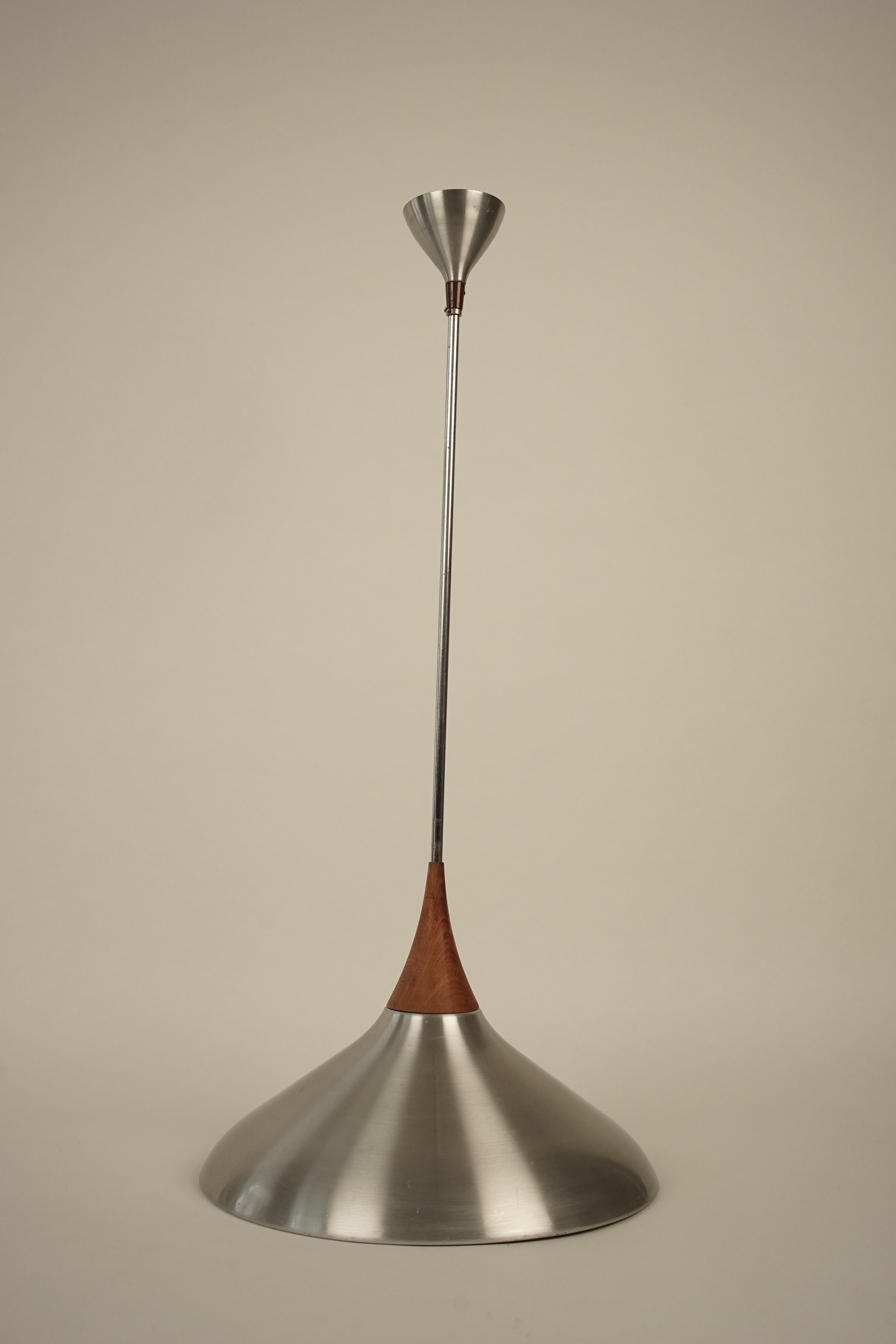 Aluminium pendant lamp with details in teak wood, in an elegant form.
Manufactured in 1960s in Czechoslovakia.