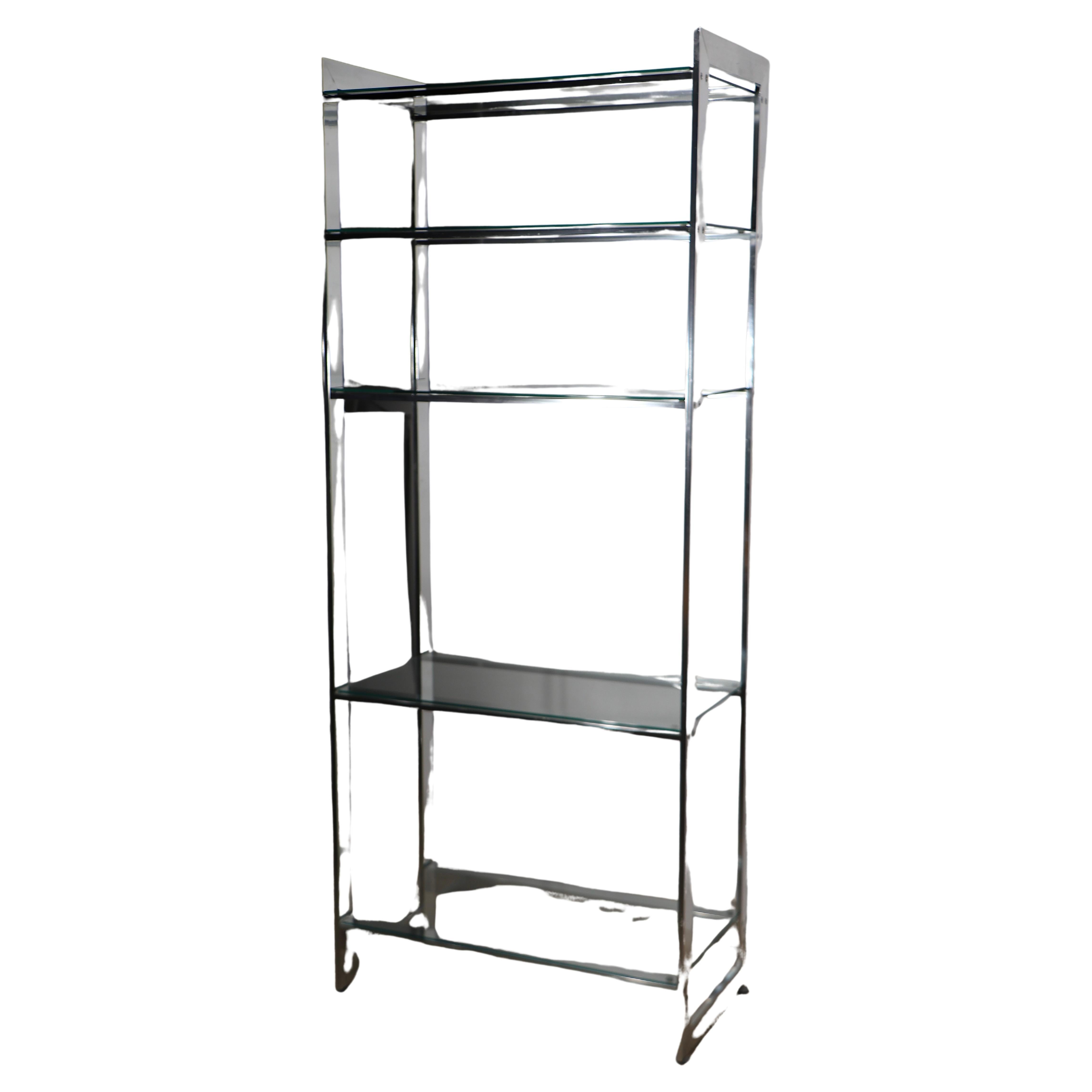 Chic, architectural freestanding shelf unit, having an aluminum frame with five glass shelves. This Etagere is reminiscent of the designs of Milo Baughman, Paul Magen etc, it is unsigned. This example is is very fine, clean, original and ready to