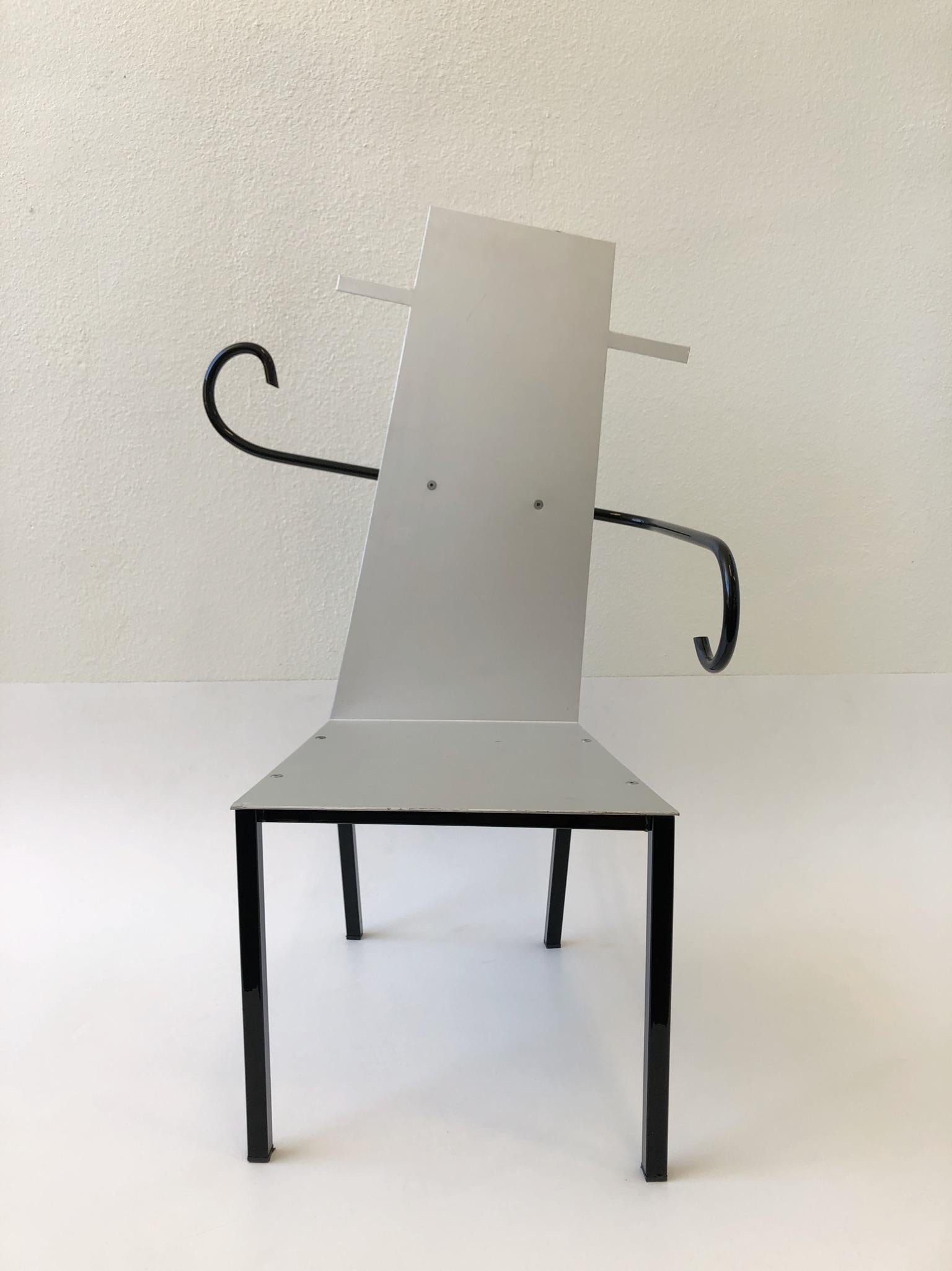 A spectacular Italian Postmodern sculptural armchair from the 1980s.
The black part of the chair is powder coated steel and the seat and back is satin aluminum. There is minor wear to the seat (see detail photos).