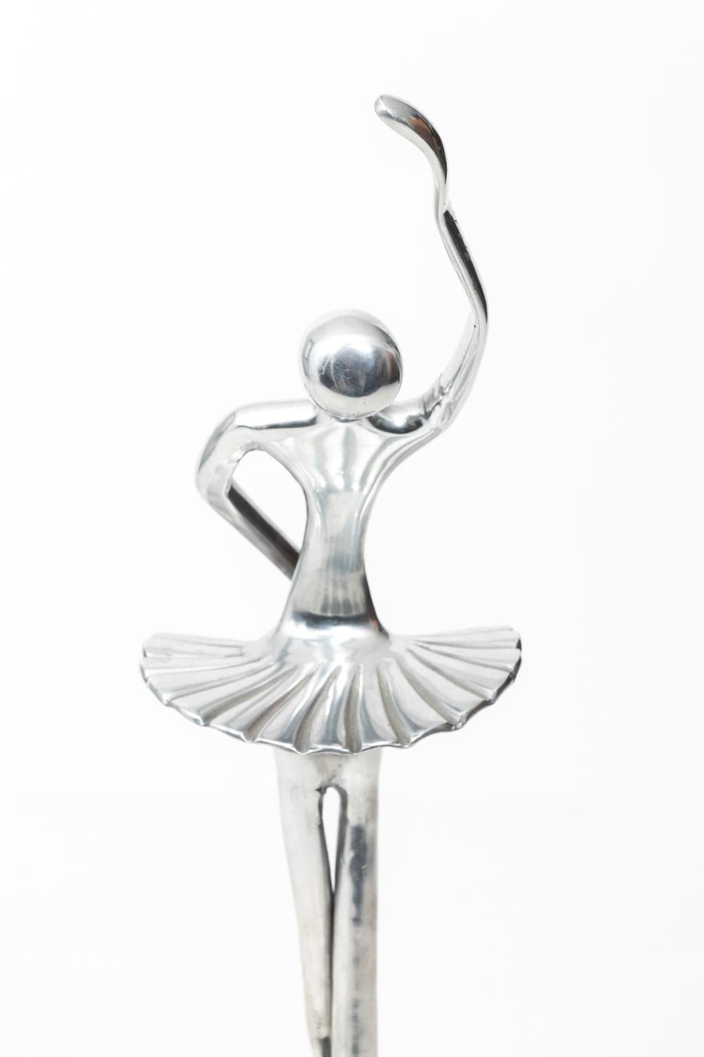Tall aluminum Ballerina sculpture on stand.