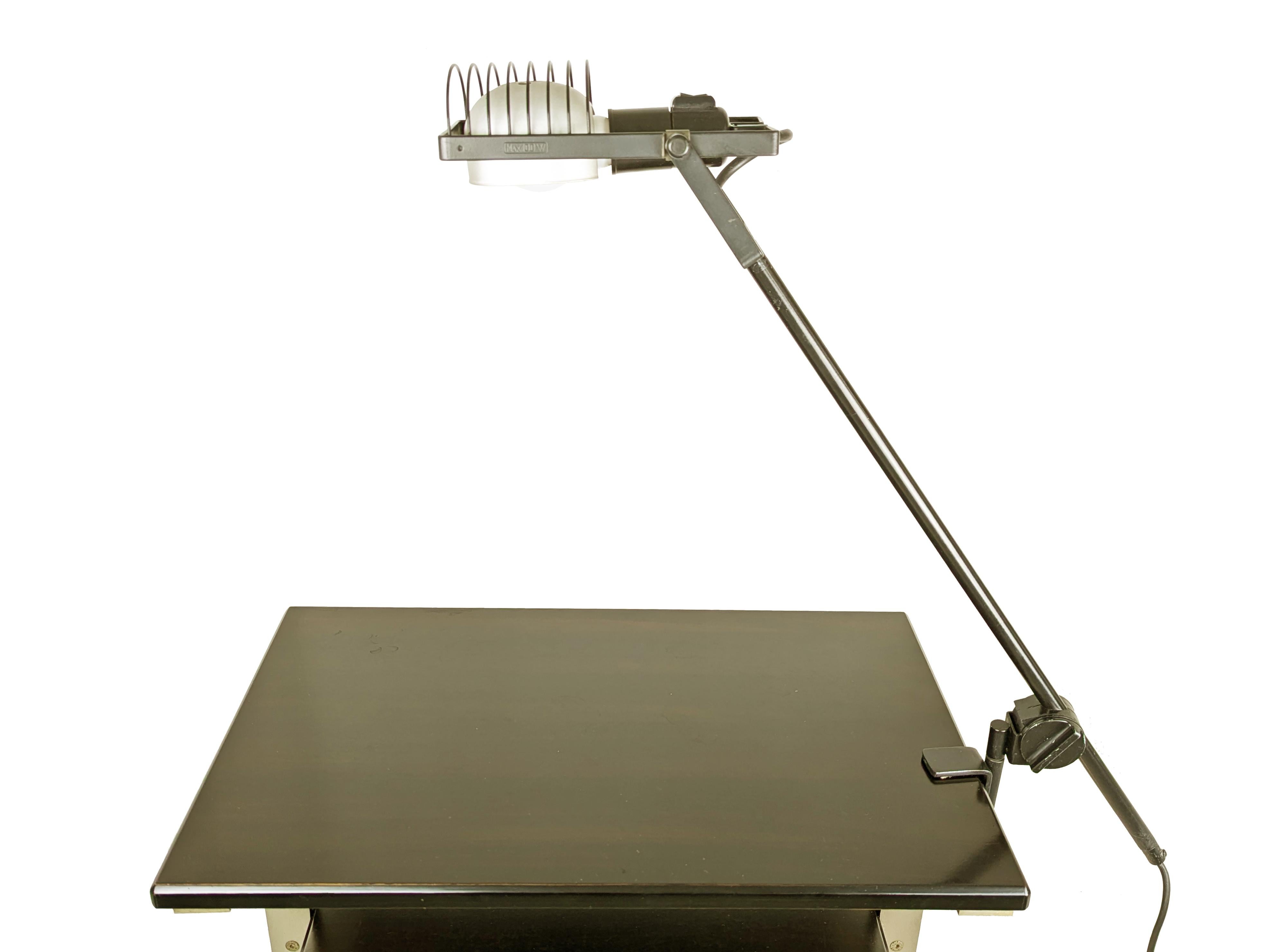 Black metal and aluminum table lamp designed by Ernesto Gismondi in the 70s for Artemide. 
Rare version with clamp attachment, adjustable in height and width thanks to the clamp equipped with pin and knob for locking.
Very good vintage condition: