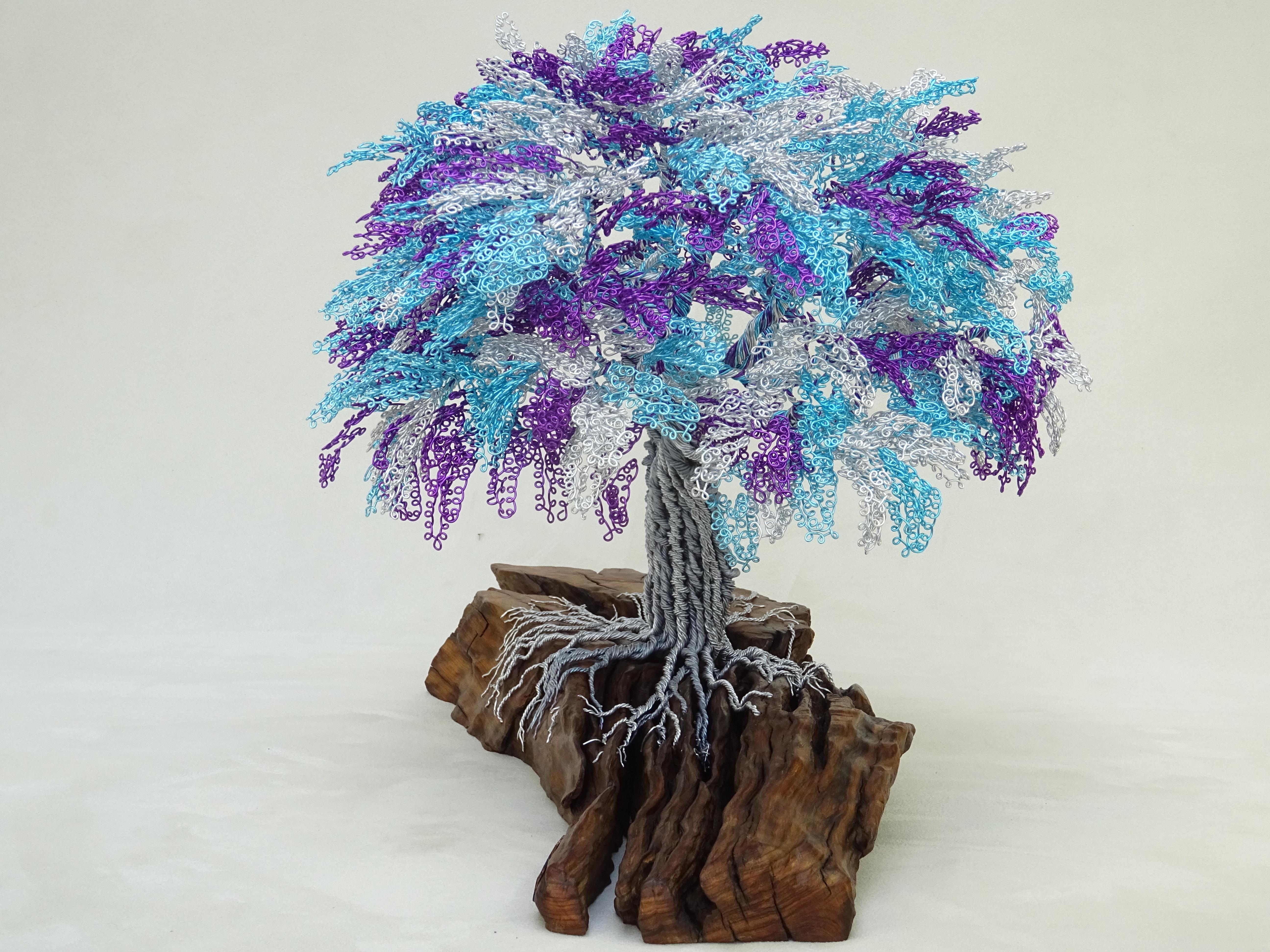 The Latin Vibes Bonsai is inspired by the Jacaranda Tree.
The artisan always takes inspiration from nature and natural events. 
The materials are wood and metals, representing both the strength of life and the roots of Mother Nature.
Sculptures