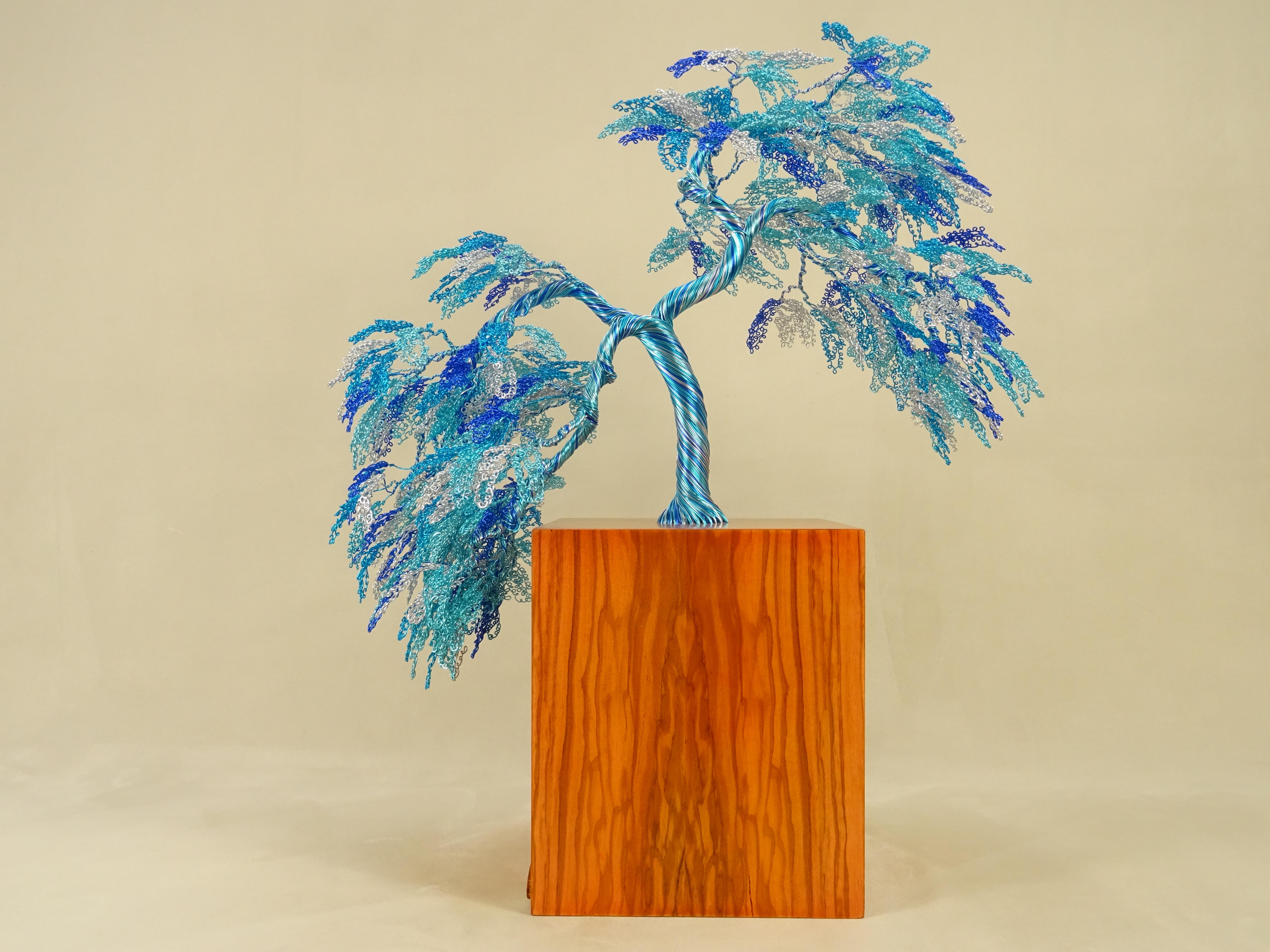 The Obeisance Bonsai is inspired by the beautiful Japanese trees and their flowering. 
The materials are wood and metals, representing both the strength of life and the roots of Mother Nature.
Sculptures are composed by wires that intertwine each