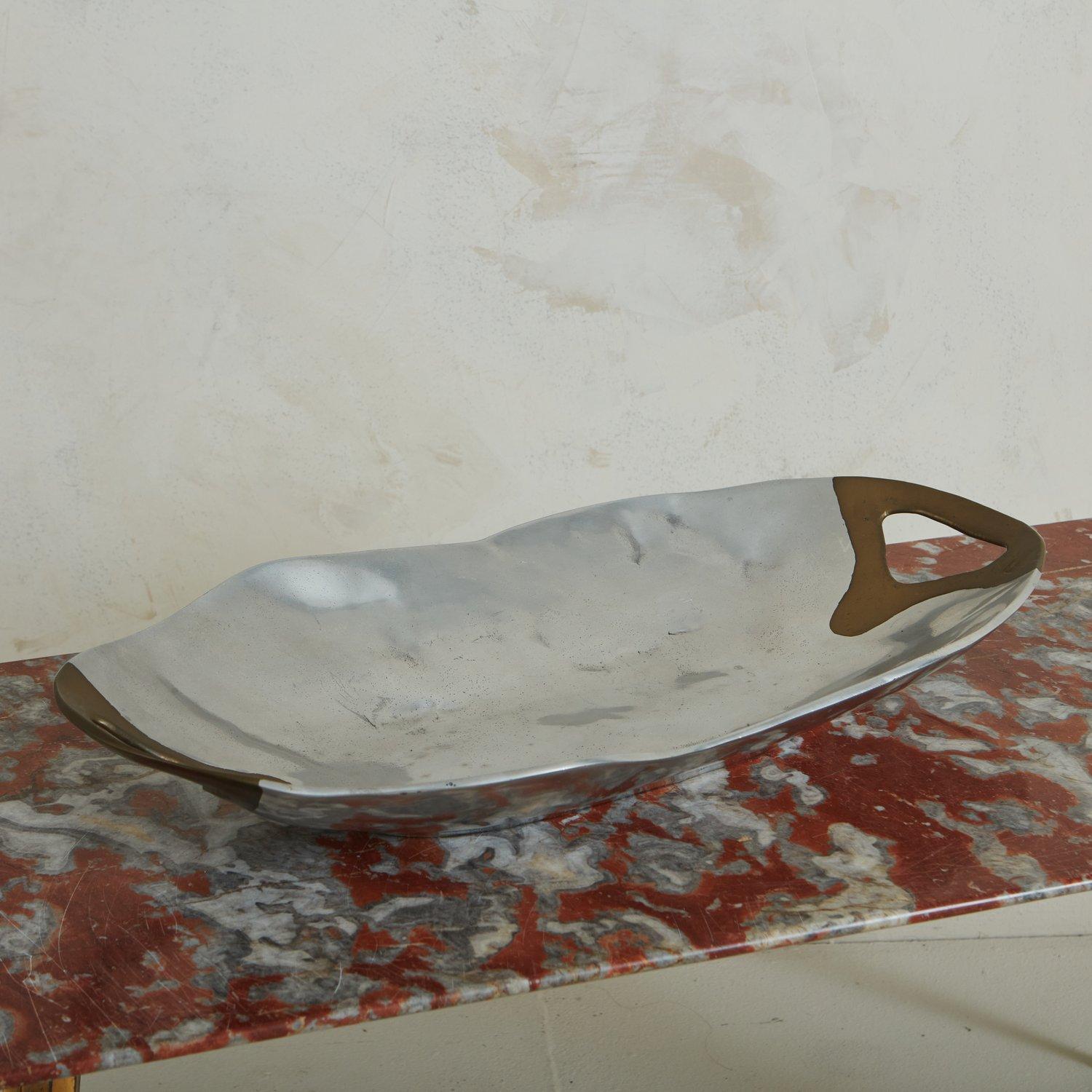 A handsome 1980s aluminum + brass oval tray by David Marshall. Marked ‘David Marshall Diseños S.A. Made in Spain” on base. Sourced in Spain, 1980s.

A similar tray by David Marshall is available.