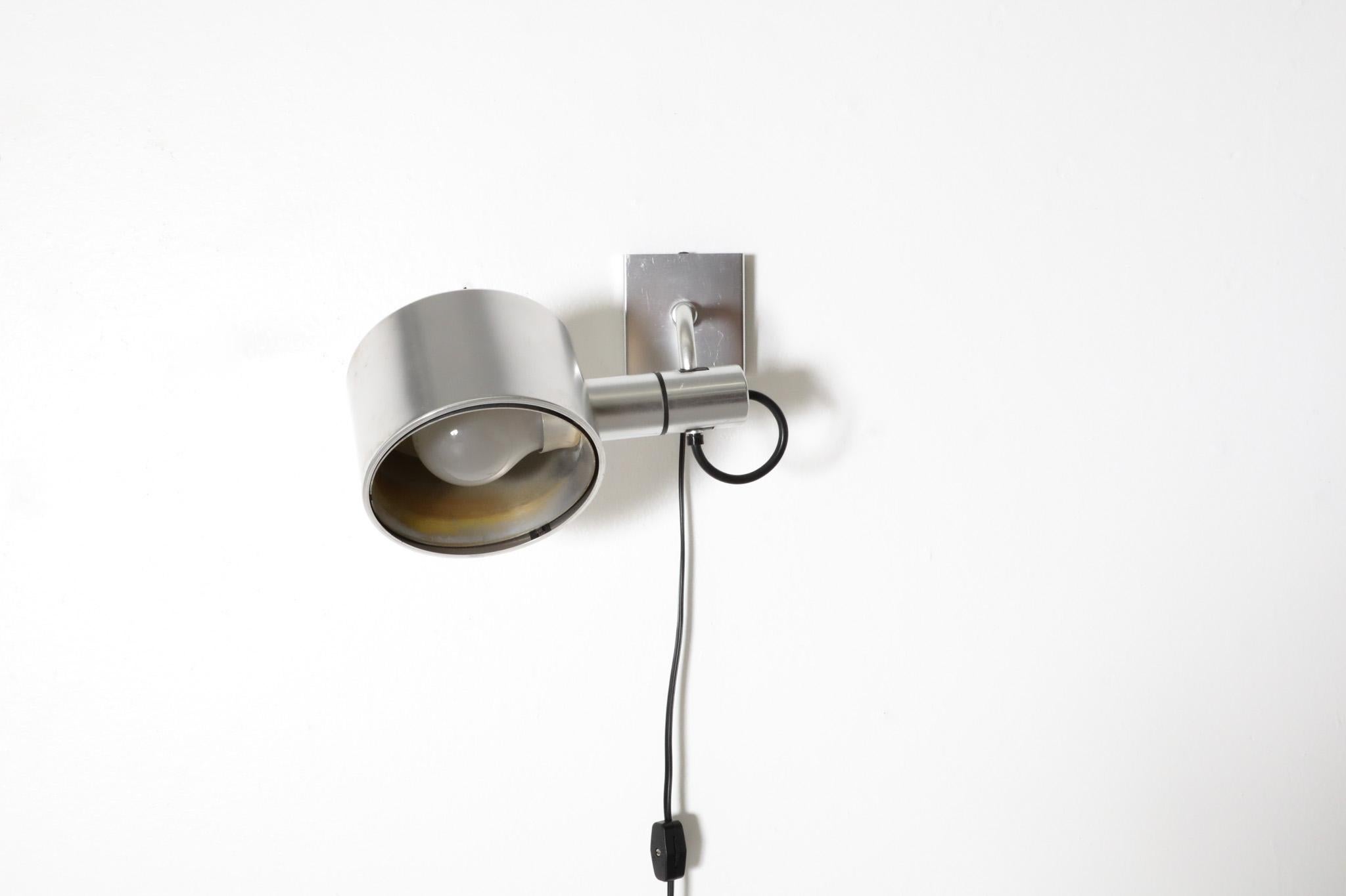Mid-Century, aluminum wall mounted pill box spot light designed by British desgners Ronald Holmes & Peter Nelson for Conelight Limited sometime in the 1970's. The Conelight Limited company was founded after World War II in October 1946 and ended