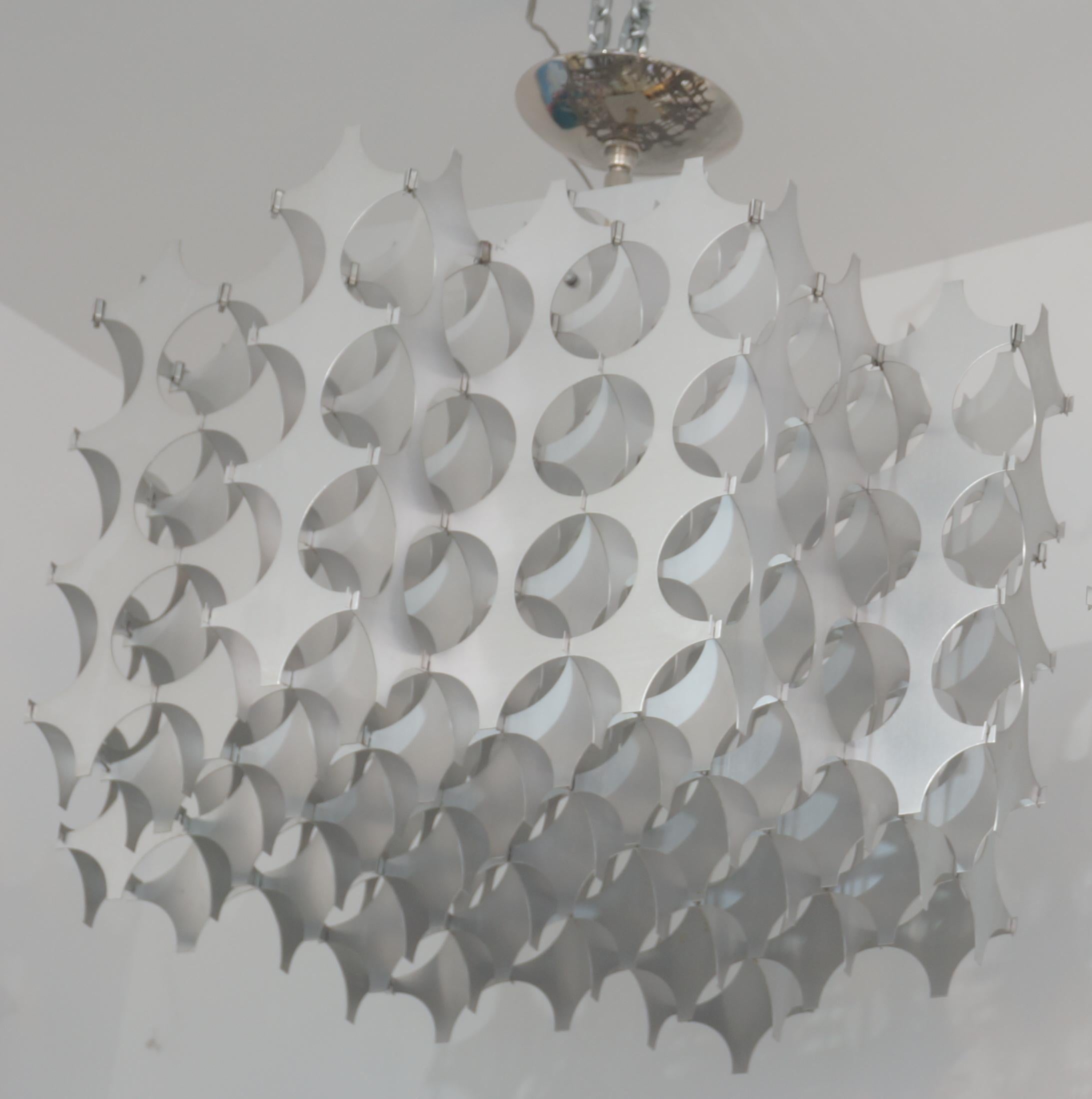 Dieser stilvolle, optische Kronleuchter aus gestanztem Aluminium stammt aus den 1970er Jahren und wurde von Max Sauze entworfen. 

Hinweis: Benötigt eine Edison-Glühbirne.

Hinweis: Die Gesamthöhe beträgt 22