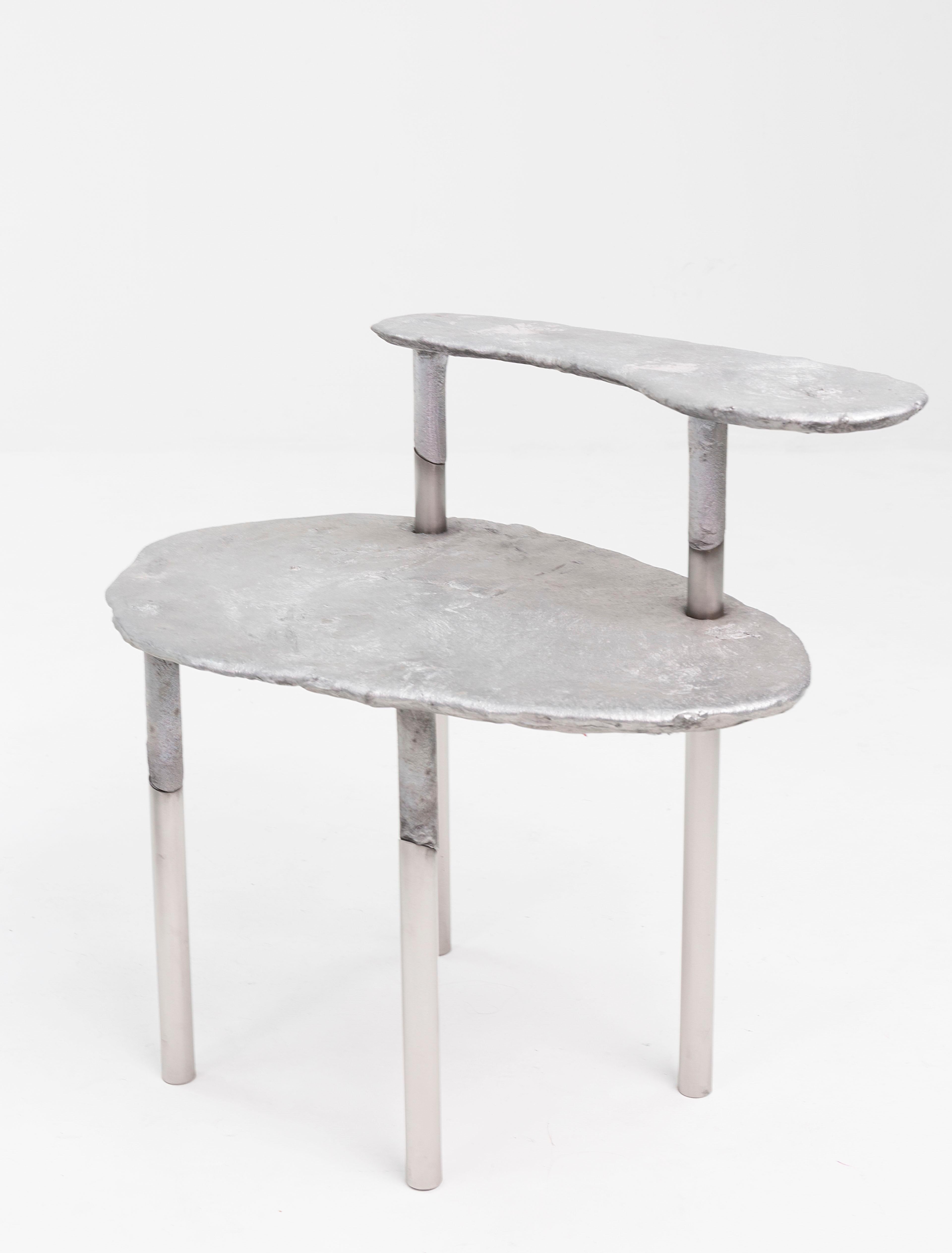 Aluminum concretion stool by Studio Julien Manaira
Dimensions: 68 x 47 x 65 cm
Materials: Aluminum, stainless steel

The concretion project consists of sand-casting aluminum in a base of stainless steel tubes to form objects. The tubes are