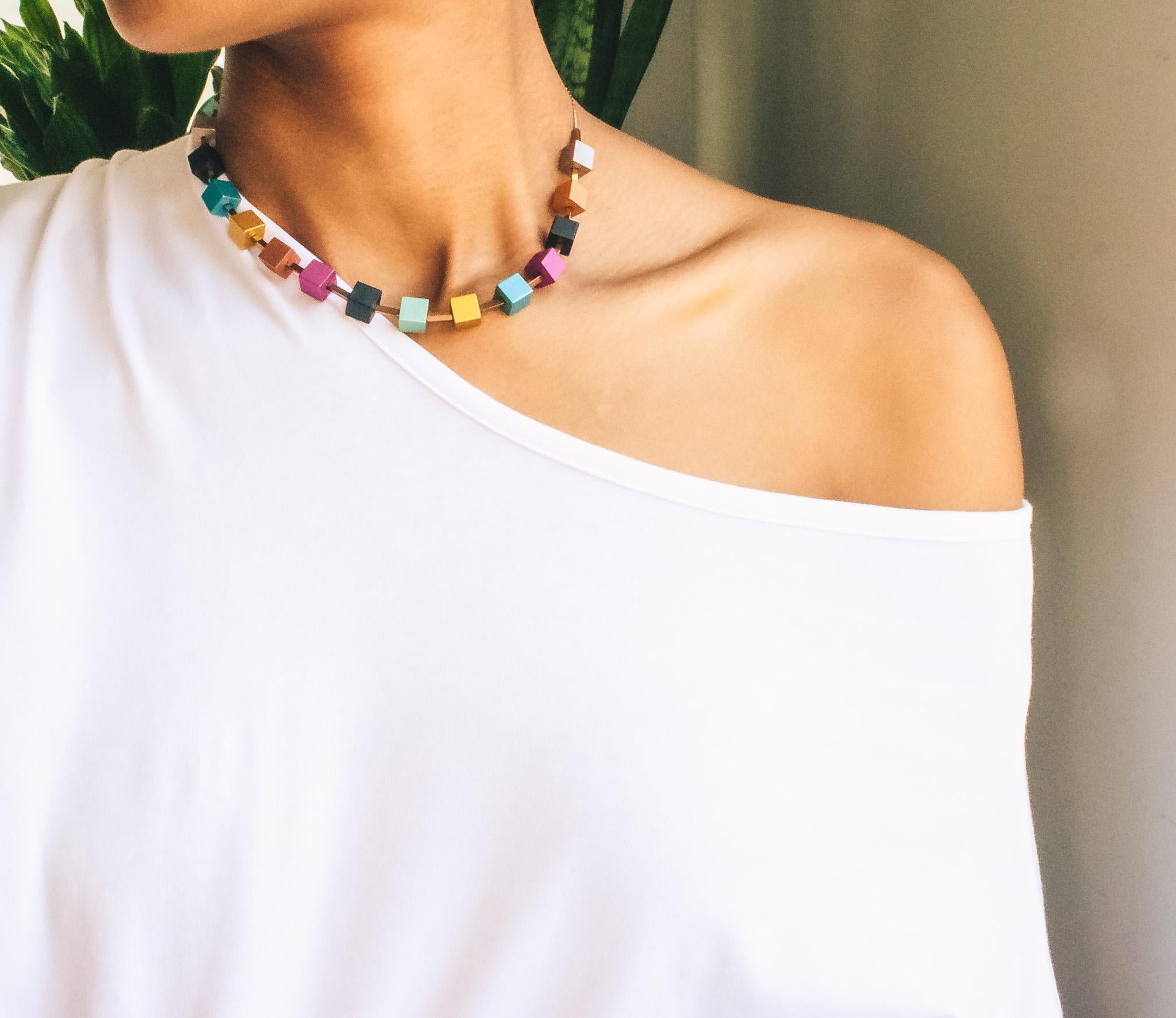 The alluring hues of satin finished cube shaped anodized aluminum is displayed in this collar necklace. The cubes are 8mm and is strung alternatively with electroplated antique gold hematite.  A very popular piece for Trecy Bleich jewelry