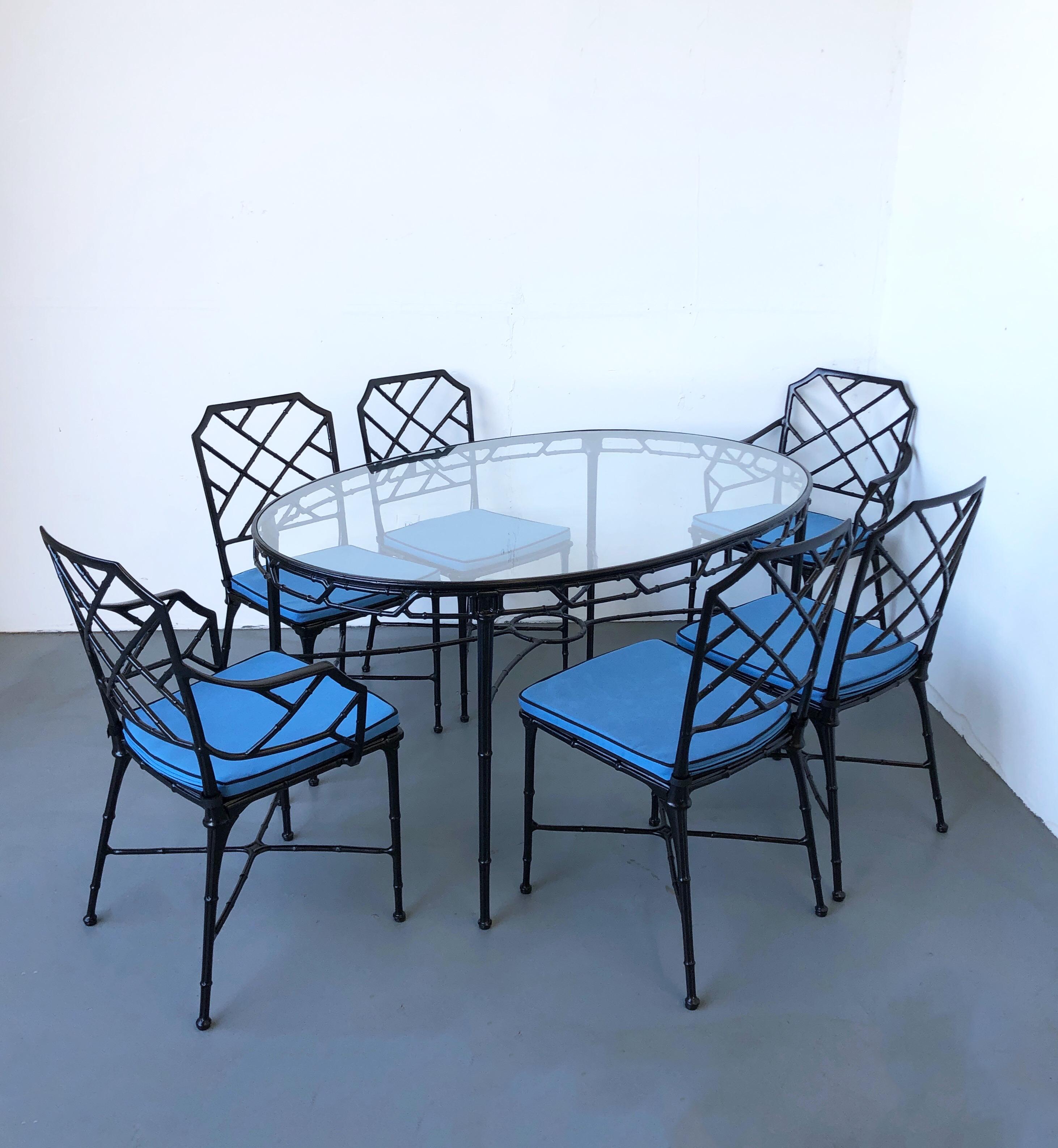 Black aluminum faux bamboo “Calcutta” patio set by Brown Jordan. 
The set consists of oval dining table, two arm chairs and four side chairs. 
Newly powder coated, new glass top and lite blue Sunbrella seat cushions. 

Measurements: 
Table-