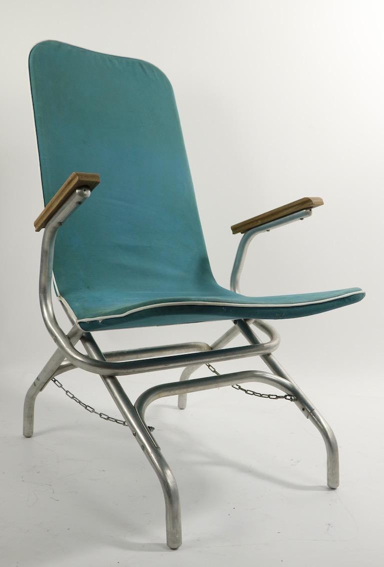 Architectural chaise lounge chair having a tubular aluminum frame, canvas sling seat and back, and wood armrests. Perfect chair for backyard, patio or poolside relaxation. The lounge is in very good original condition, clean and ready to use.