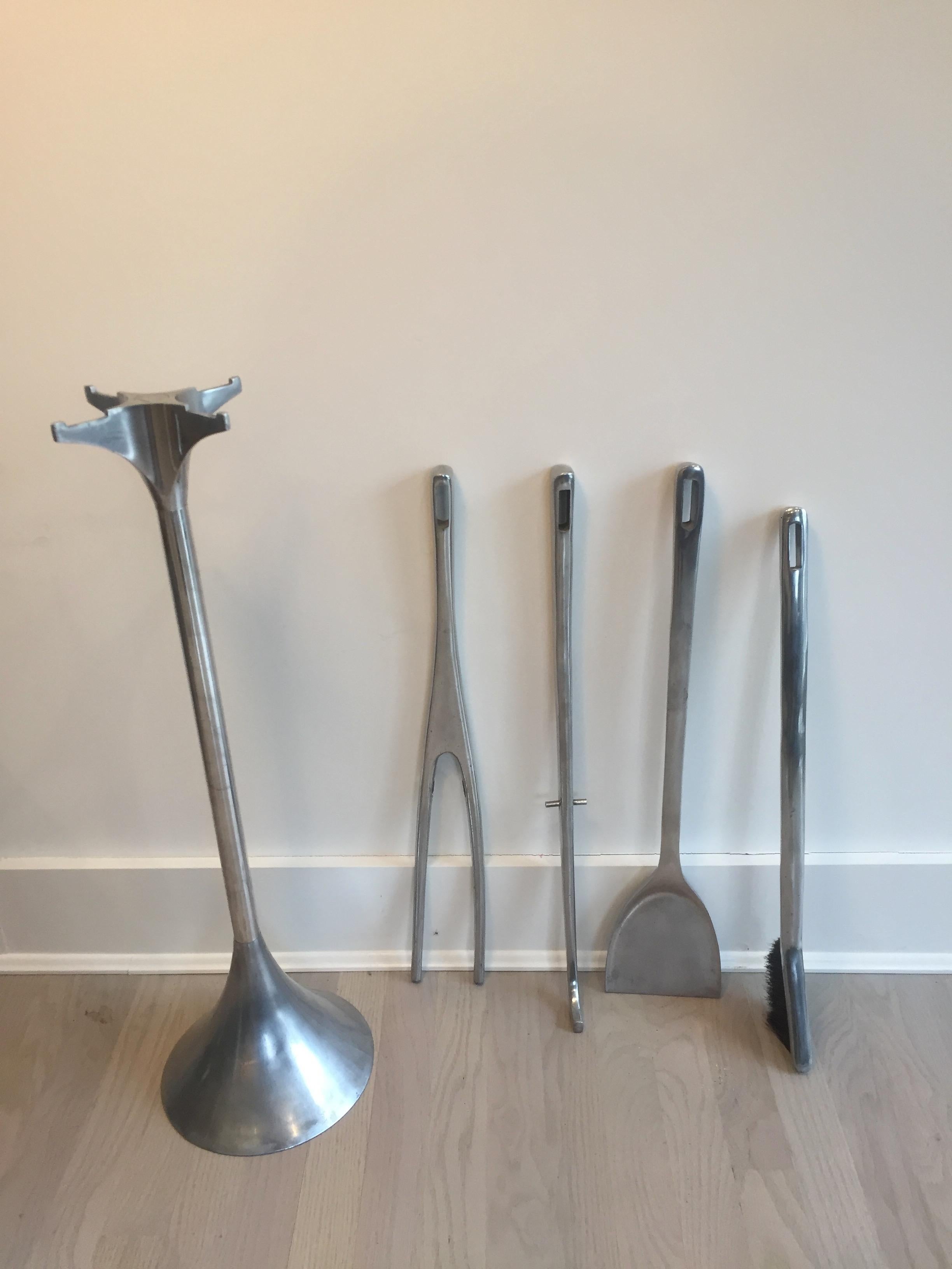 Aluminum ‘Fuego’ fireplace tool set by Umbra. Manufactured in the 1980s this has become a collectors item. Set comprises of a stand, poker, brush, shovel, hook and the log carrier with a leather saddle(which is hard to find). Slight age
