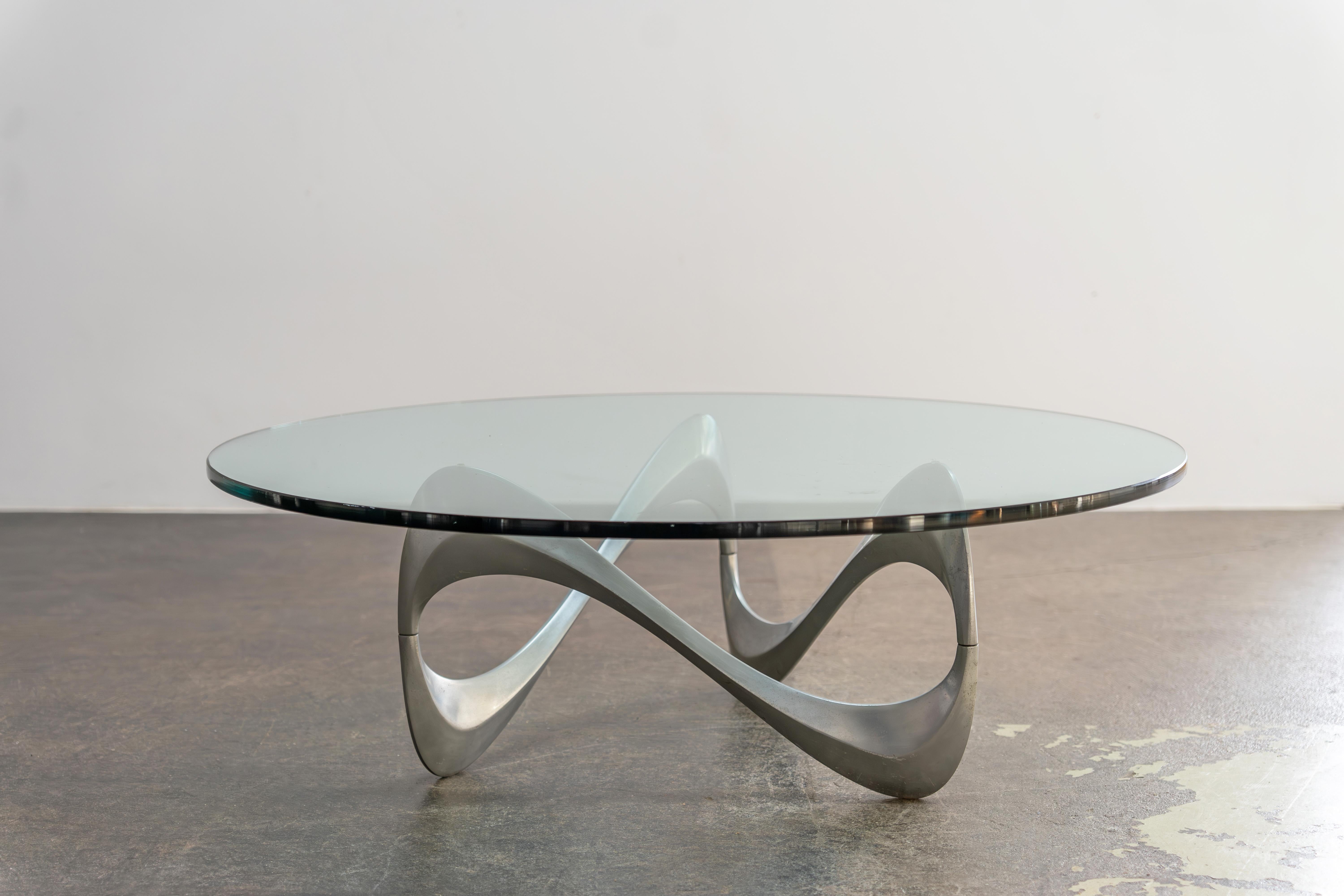 Der Snake Couchtisch von Knut Hesterberg - ein zeitloses Meisterwerk aus fließender Form und minimalistischer Ästhetik. Wo Kunst auf Funktion trifft. Ein skulpturaler Aluminiumsockel und eine dicke Glasplatte, Deutschland 1960er Jahre.

