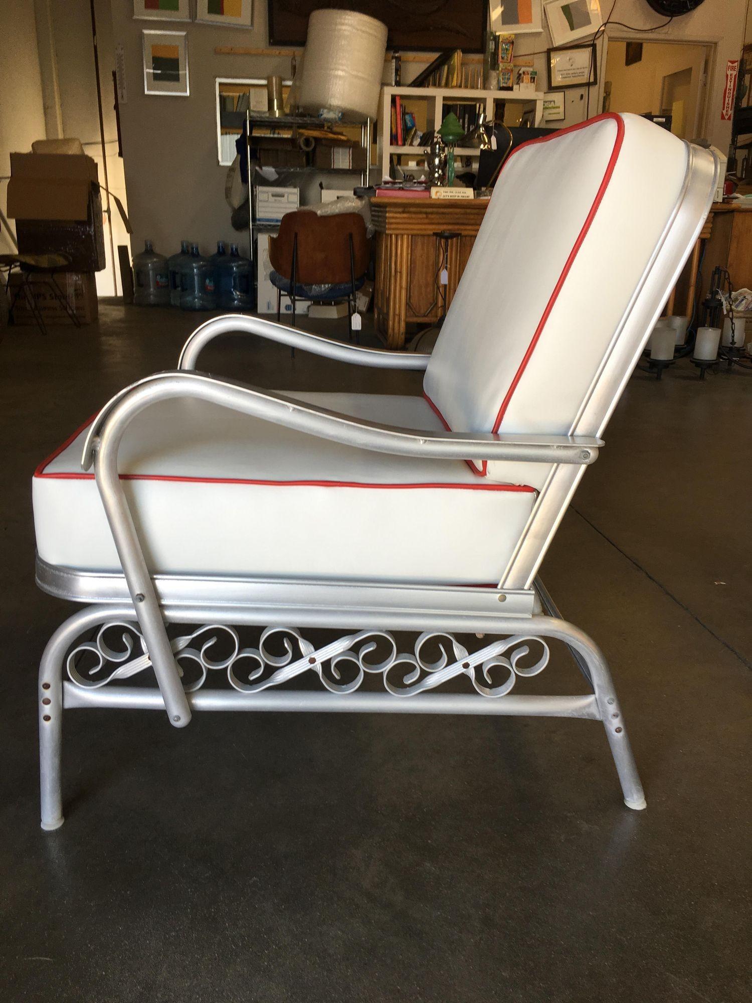 Mid-century patio/outdoor lounge chair consisting of an aluminum body with decorative scrolling patterns along the side. This large outdoor lounge chair is consistent with the size of lounge chairs normally found in the living room with a deeper